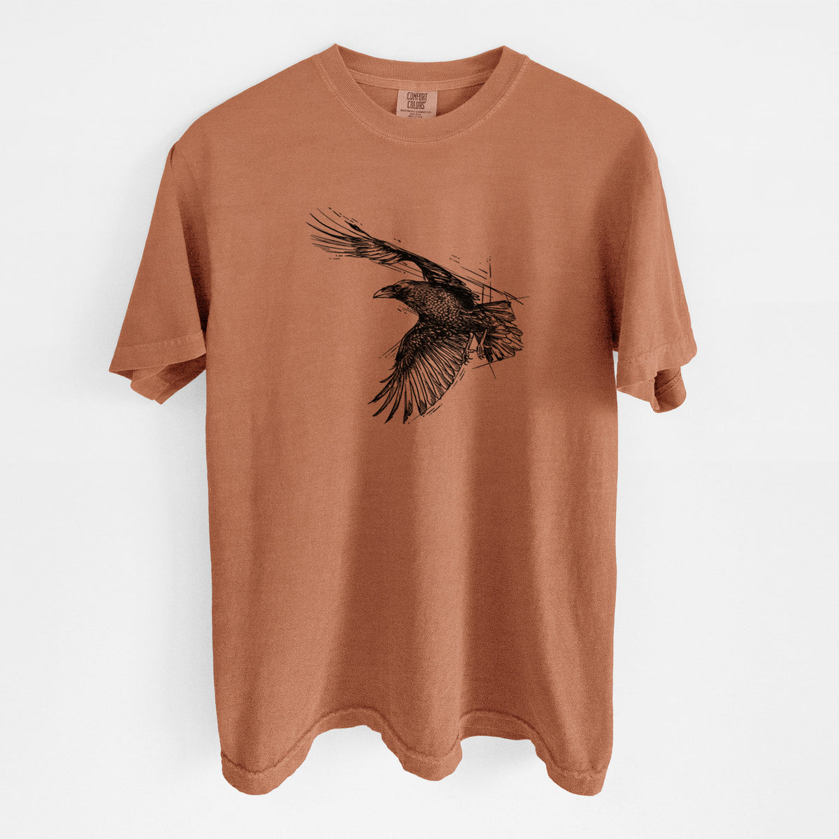 Yam burnt orange Comfort Colors t-shirt laid flat, printed with a black ink illustration of a raven in flight with its wings spread.