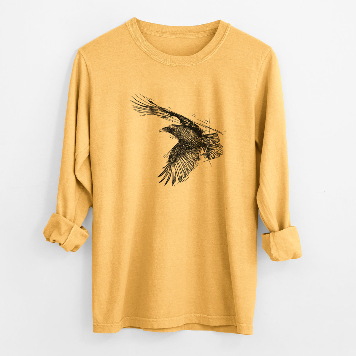 Golden wheat yellow Comfort Colors long sleeve shirt laid flat with the cuffs rolled, printed with a black ink illustration of a raven in flight with its wings spread.
