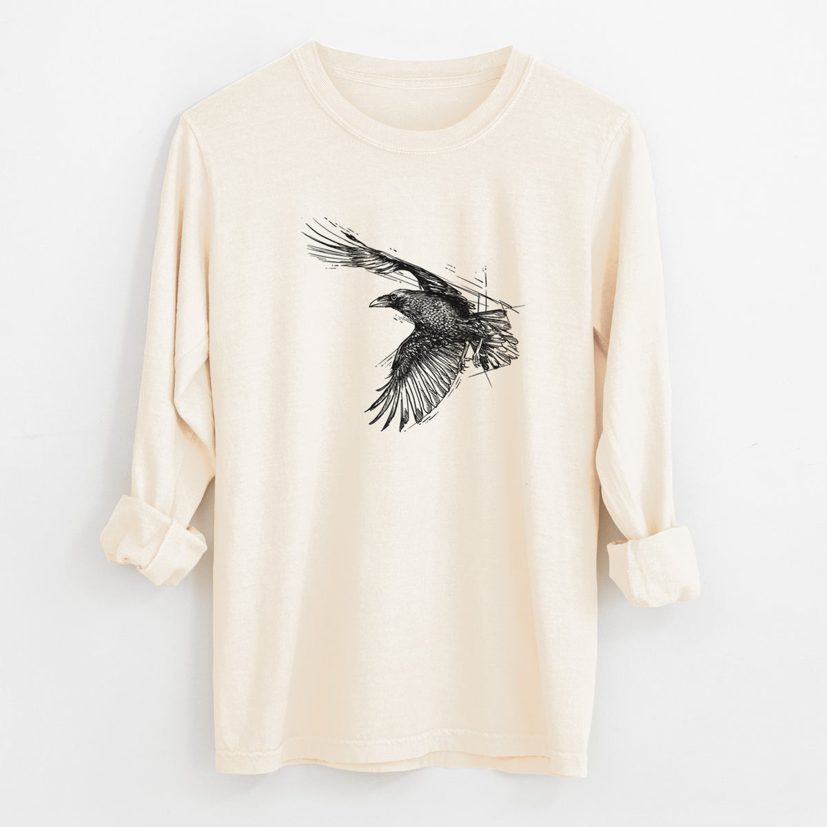 Ivory Comfort Colors long sleeve shirt laid flat with the cuffs rolled, printed with a black ink illustration of a raven in flight with its wings spread.