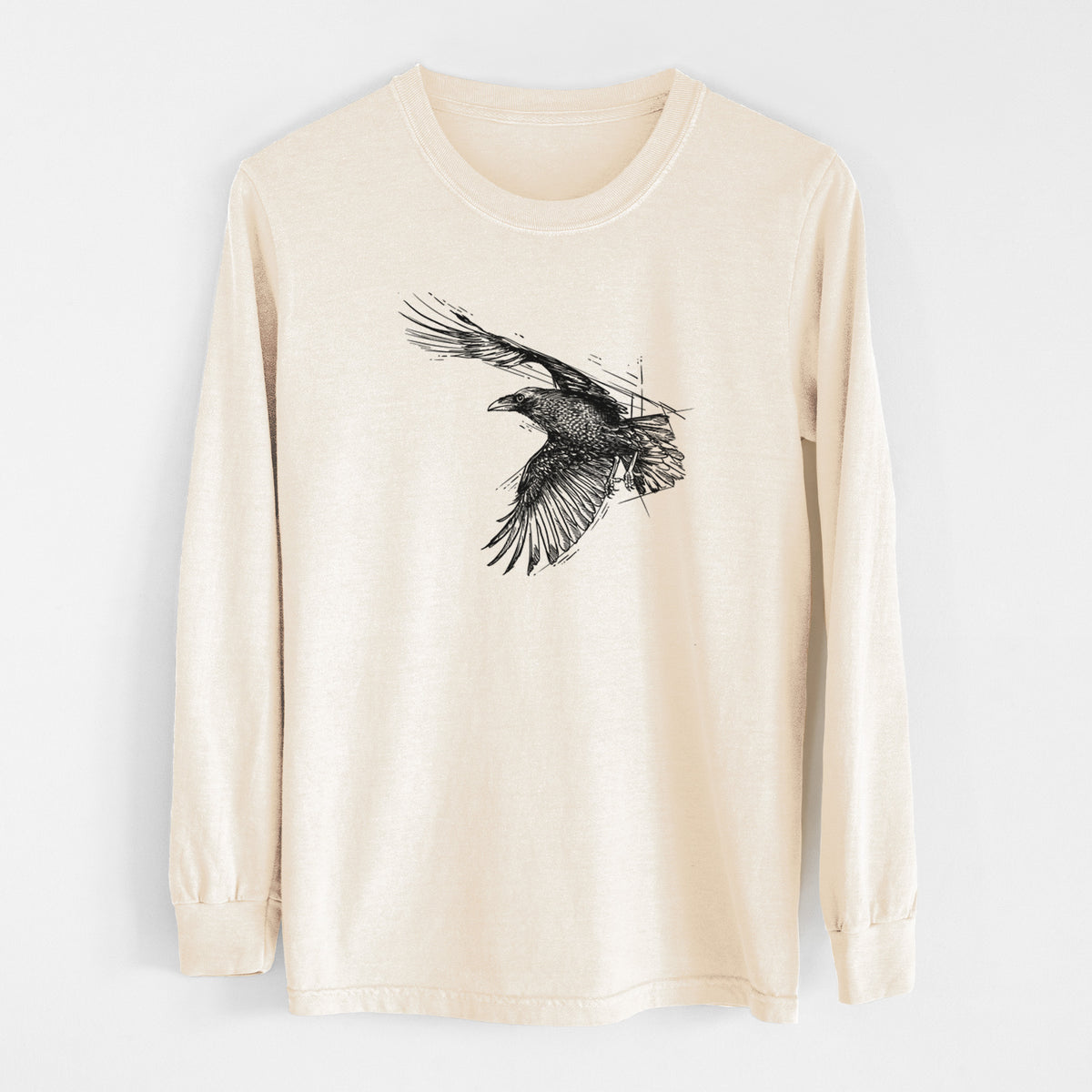 Ivory Comfort Colors long sleeve shirt laid flat, printed with a black ink illustration of a raven in flight with its wings spread.