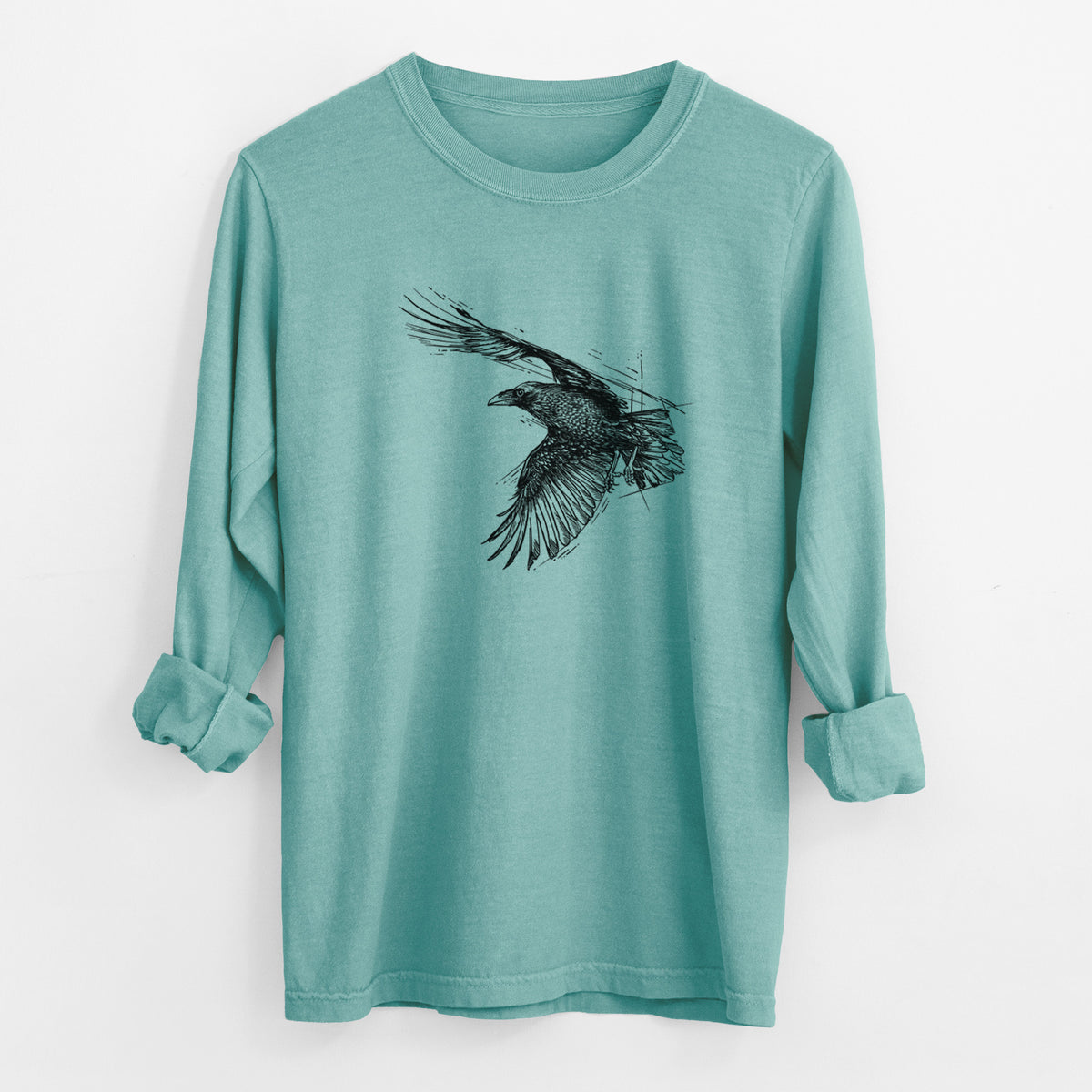 Reef green Comfort Colors long sleeve shirt laid flat with the cuffs rolled, printed with a black ink illustration of a raven in flight with its wings spread.