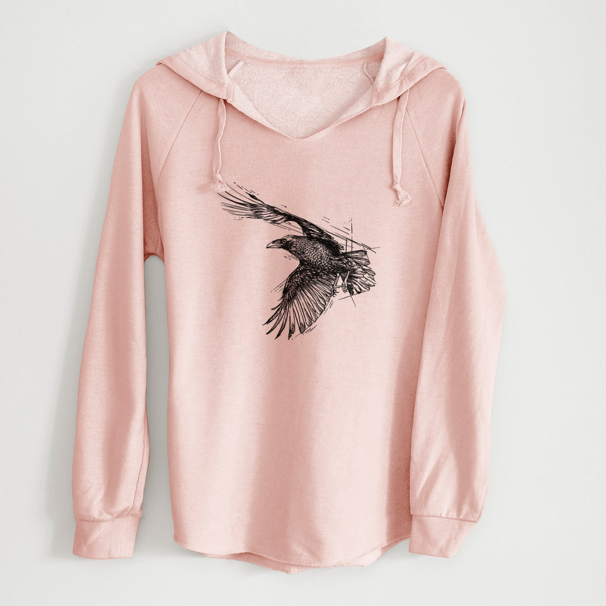 Blush pink women's Cali Wave hooded sweatshirt laid flat, printed with a black ink illustration of a raven in flight with its wings spread.