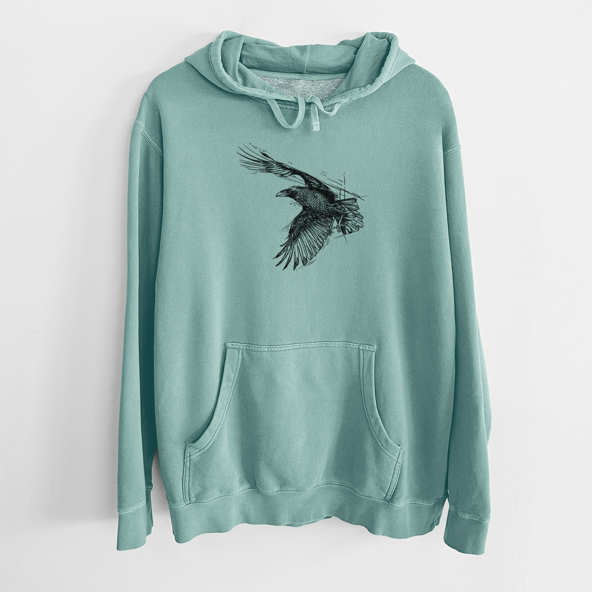 Mint green pigment dyed hoodie laid flat, printed with a black ink illustration of a raven in flight with its wings spread.