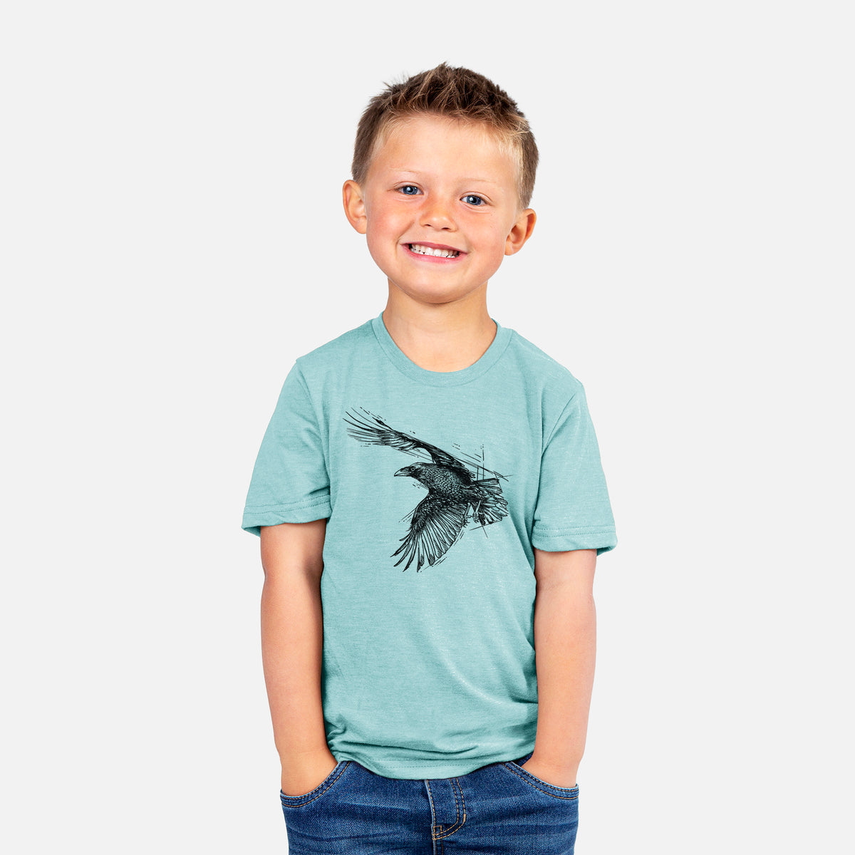 Smiling boy wearing a youth t-shirt printed with a black ink illustration of a raven in flight with its wings spread.