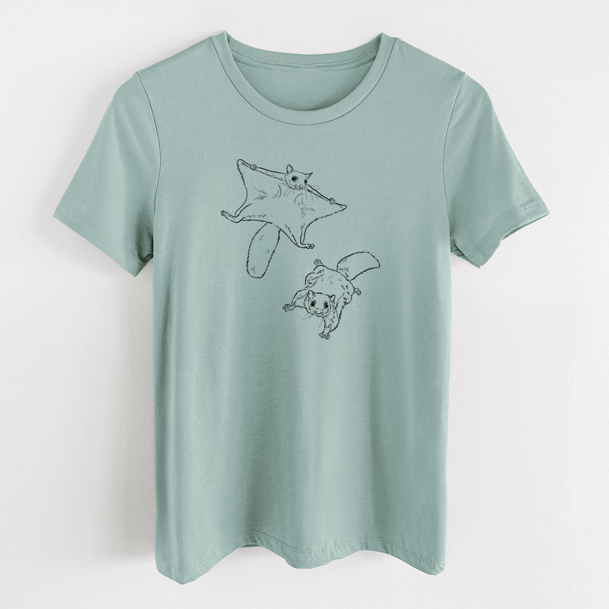 Dusty blue women's relaxed fit cotton t-shirt laid flat, printed with a black ink illustration of two flying squirrels gliding with their skin flaps spread.