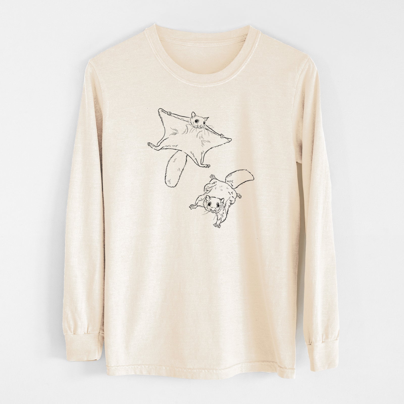 Ivory Comfort Colors long sleeve shirt laid flat, printed with a black ink illustration of two flying squirrels gliding with their skin flaps spread.