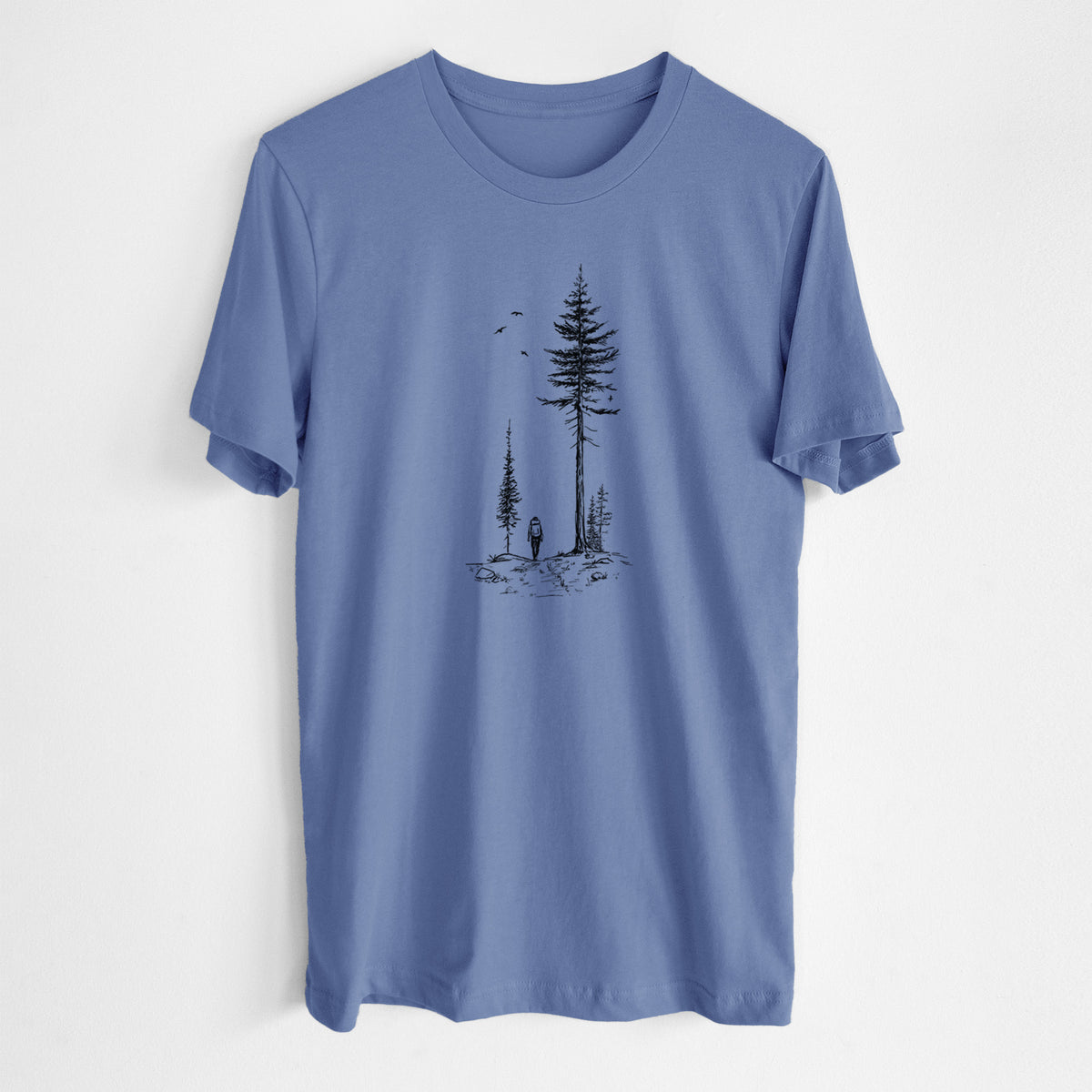 Blue bell lightweight cotton t-shirt laid flat, printed with a black ink illustration of a lone hiker walking between tall pine trees with birds overhead.