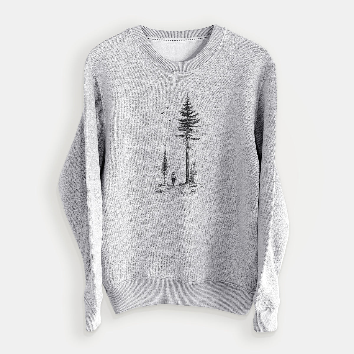 Salt and pepper knit sweatshirt laid flat, printed with a black ink illustration of a lone hiker walking between tall pine trees with birds overhead.