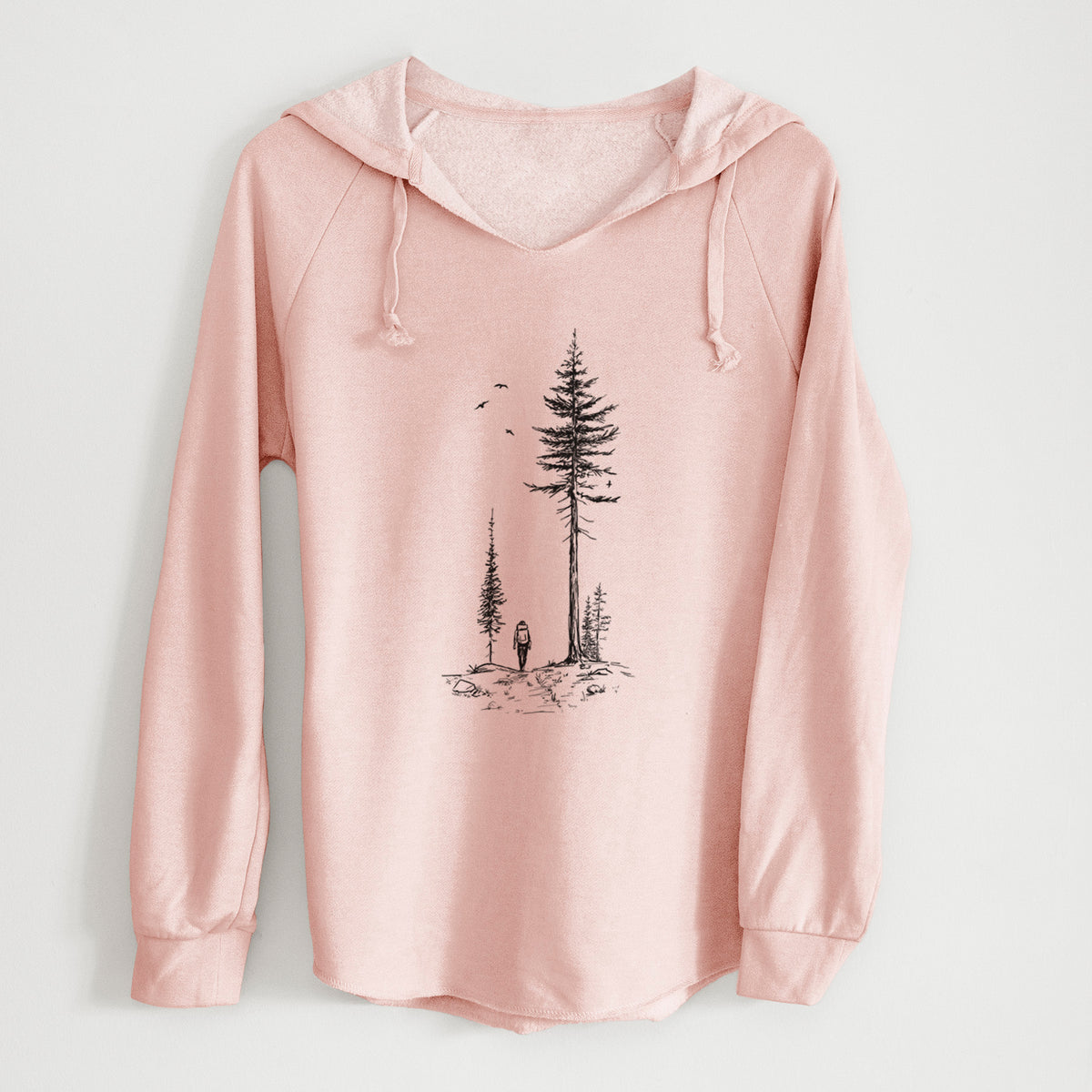 Blush pink women's Cali Wave hooded sweatshirt laid flat, printed with a black ink illustration of a lone hiker walking between tall pine trees with birds overhead.