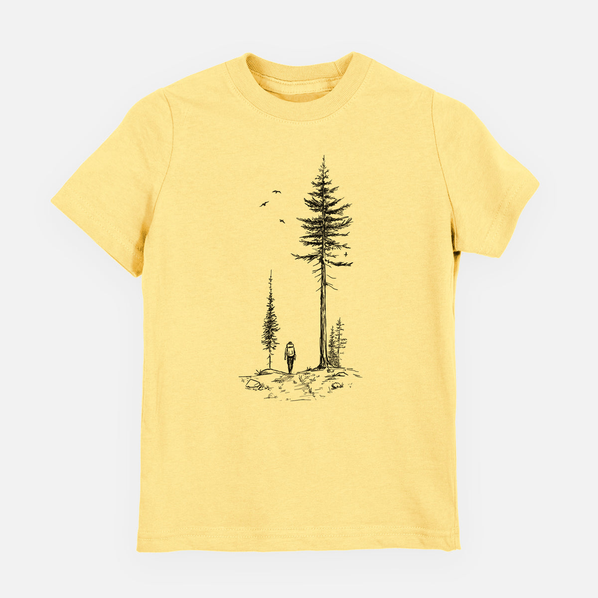 Butter yellow youth t-shirt laid flat, printed with a black ink illustration of a lone hiker walking between tall pine trees with birds overhead.