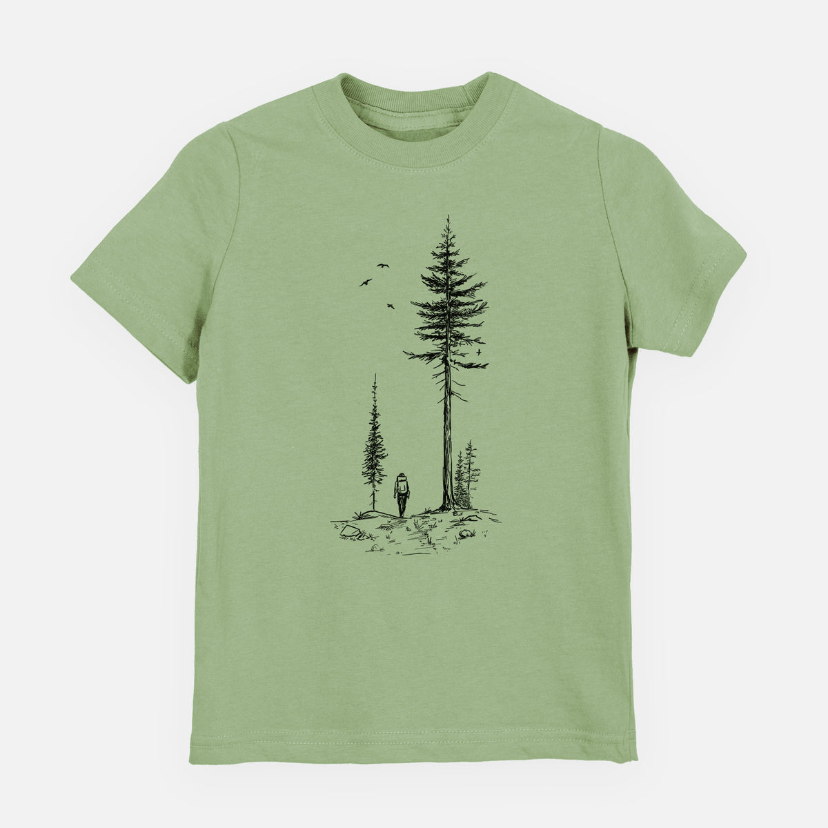 Sage green youth t-shirt laid flat, printed with a black ink illustration of a lone hiker walking between tall pine trees with birds overhead.