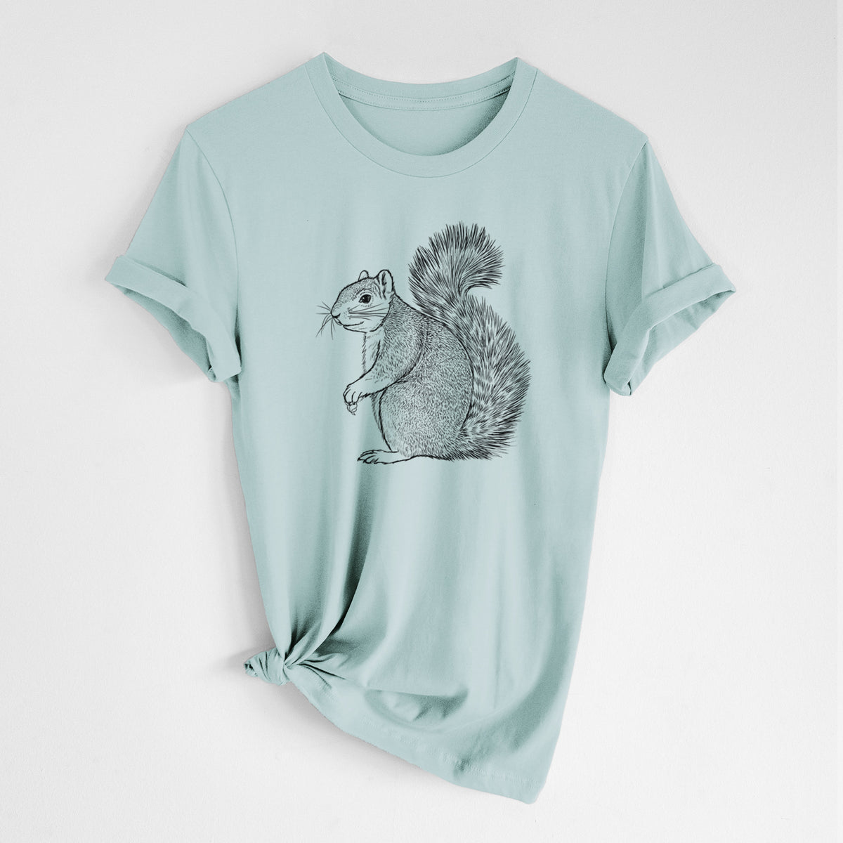 Dusty blue lightweight cotton t-shirt laid flat with the sleeves rolled, printed with a detailed black ink illustration of a fox squirrel sitting with a bushy tail.