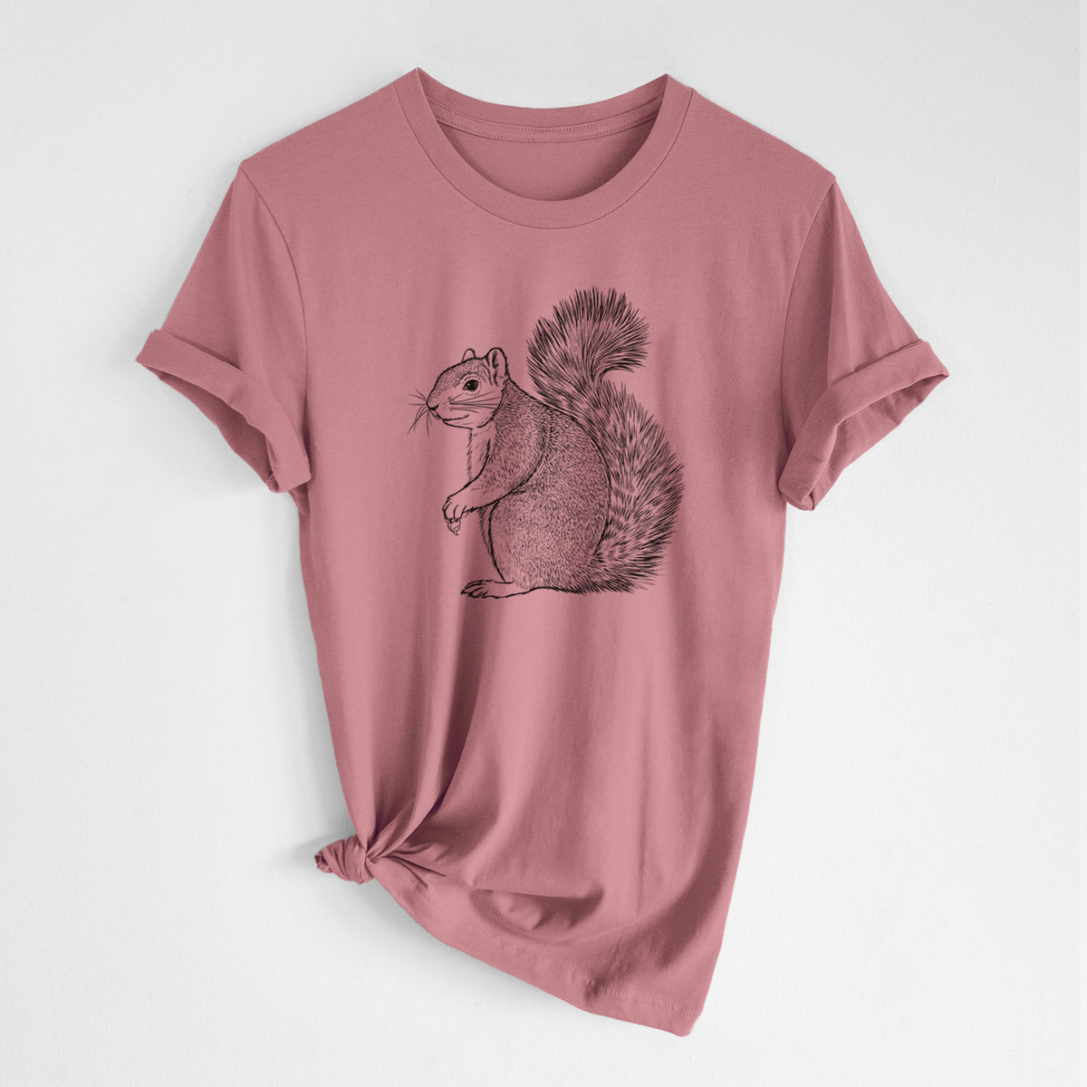 Mauve pink lightweight cotton t-shirt laid flat with the sleeves rolled, printed with a detailed black ink illustration of a fox squirrel sitting with a bushy tail.