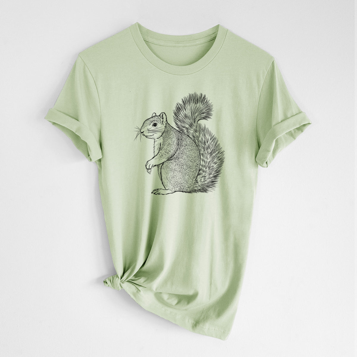 Spring green lightweight cotton t-shirt laid flat with the sleeves rolled, printed with a detailed black ink illustration of a fox squirrel sitting with a bushy tail.