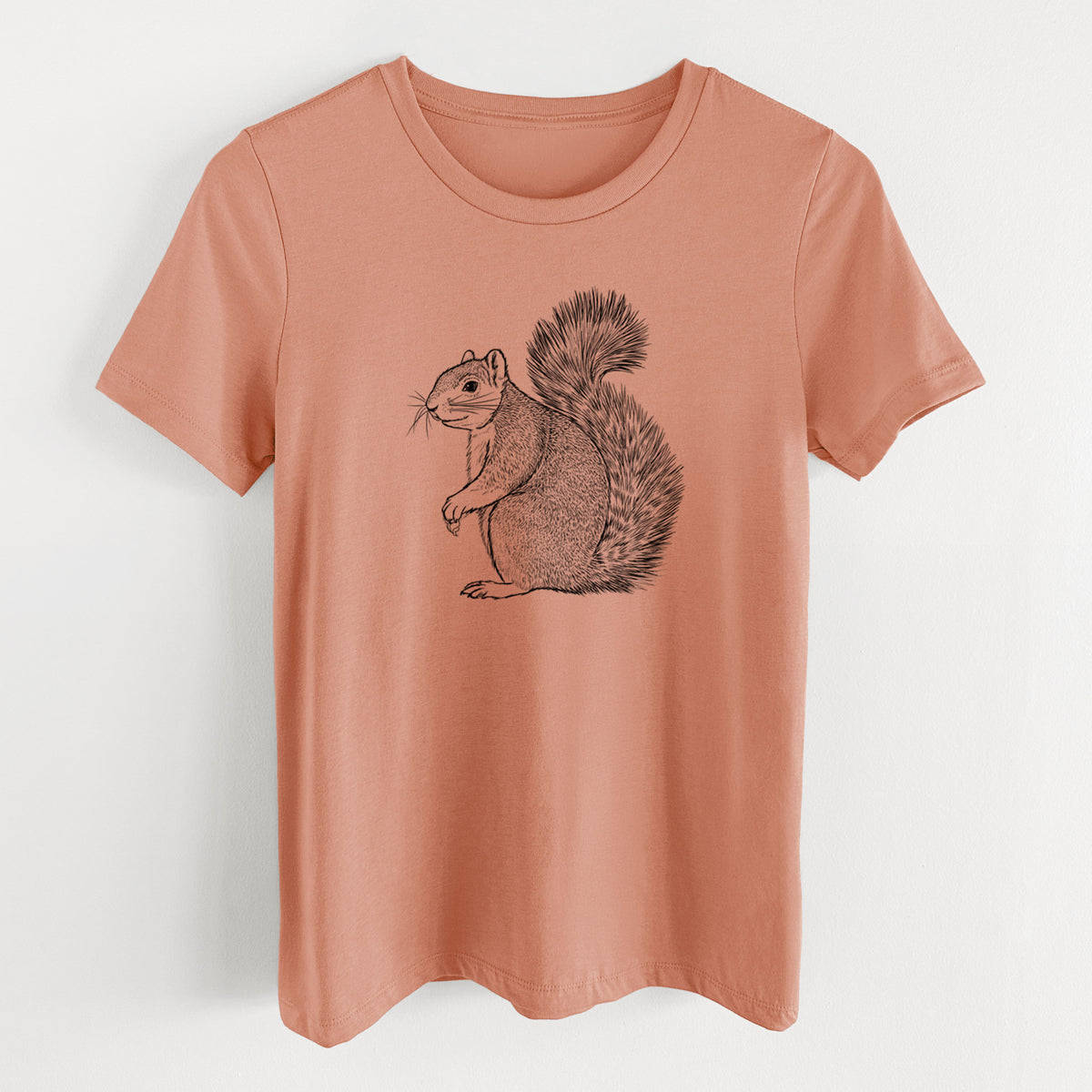 Terracotta orange women's relaxed fit cotton t-shirt laid flat, printed with a detailed black ink illustration of a fox squirrel sitting with a bushy tail.