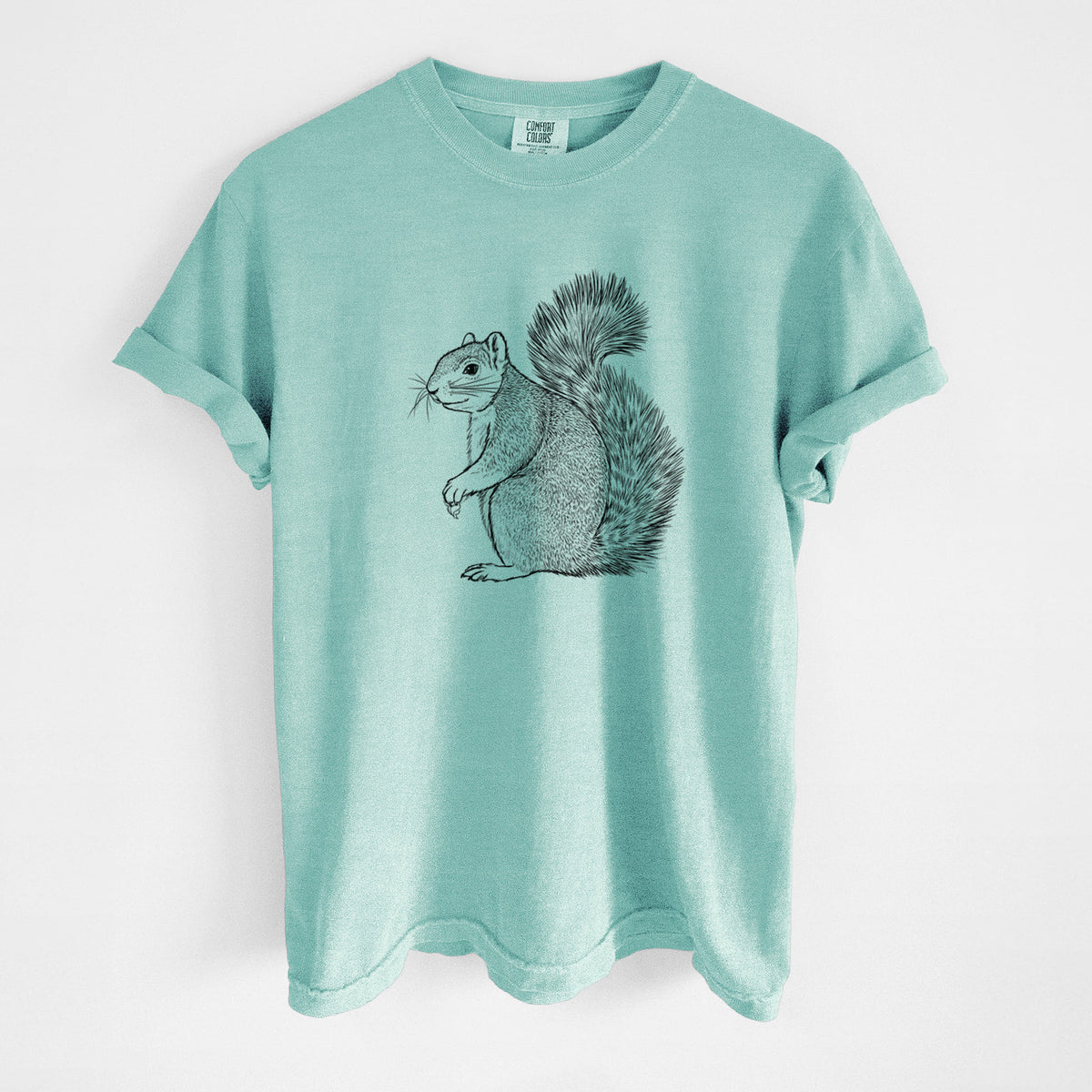 Chalky mint Comfort Colors t-shirt laid flat, printed with a detailed black ink illustration of a fox squirrel sitting with a bushy tail.