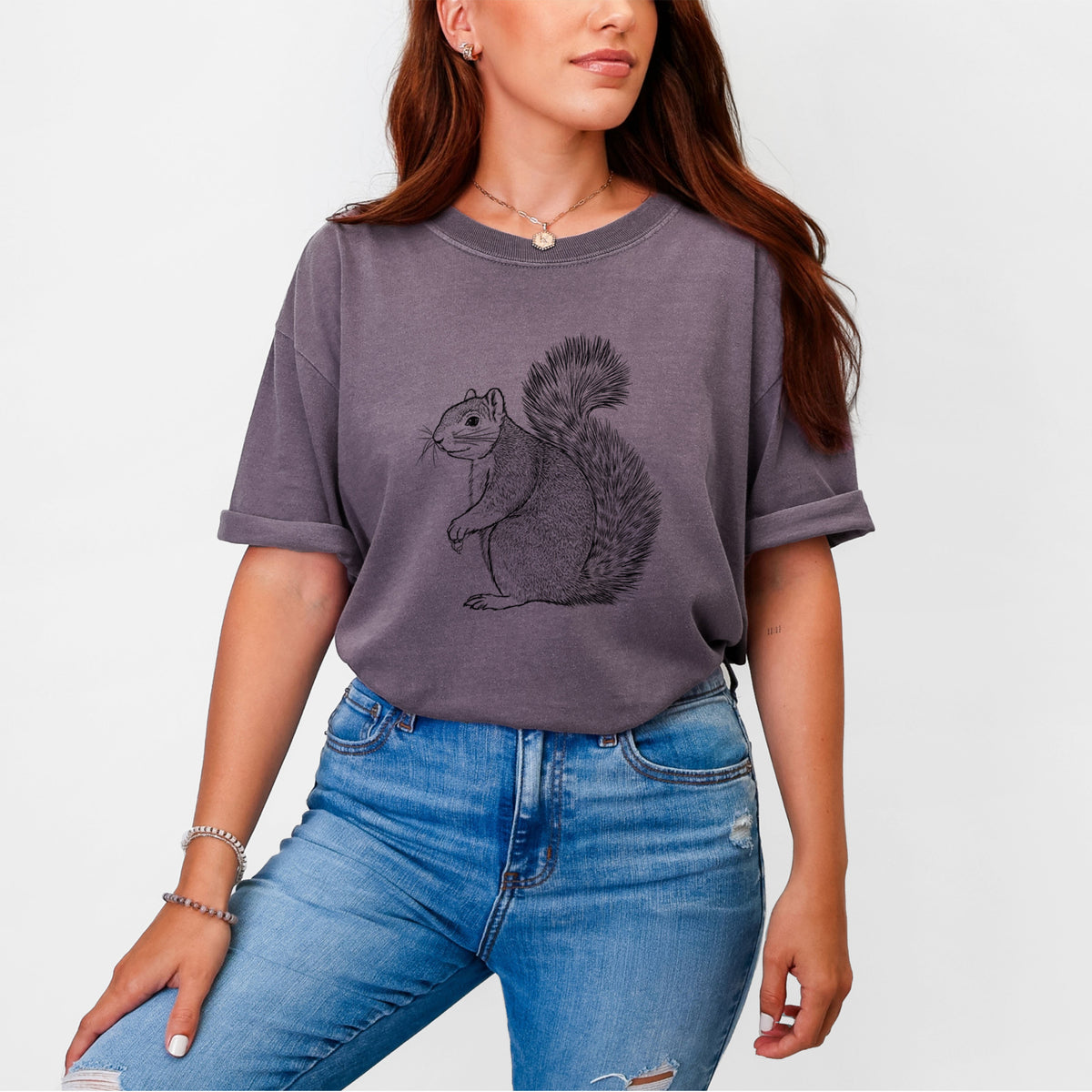 Woman wearing a Comfort Colors t-shirt printed with a detailed black ink illustration of a fox squirrel sitting with a bushy tail.