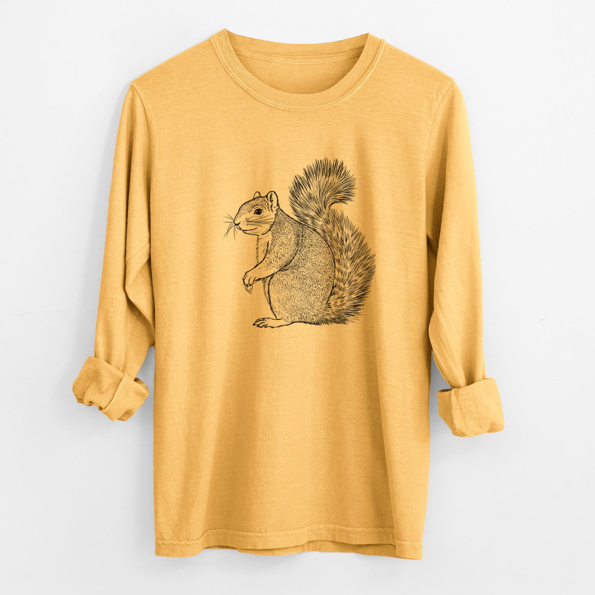 Golden wheat yellow Comfort Colors long sleeve shirt laid flat with the cuffs rolled, printed with a detailed black ink illustration of a fox squirrel sitting with a bushy tail.