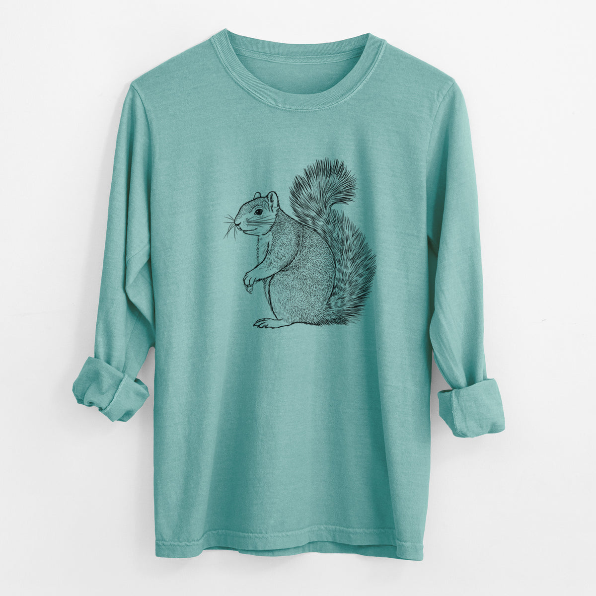Reef green Comfort Colors long sleeve shirt laid flat with the cuffs rolled, printed with a detailed black ink illustration of a fox squirrel sitting with a bushy tail.