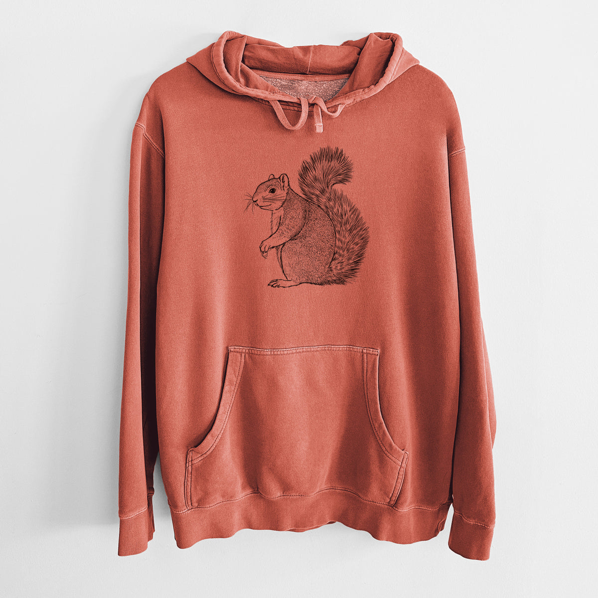 Amber orange pigment dyed hoodie laid flat, printed with a detailed black ink illustration of a fox squirrel sitting with a bushy tail.