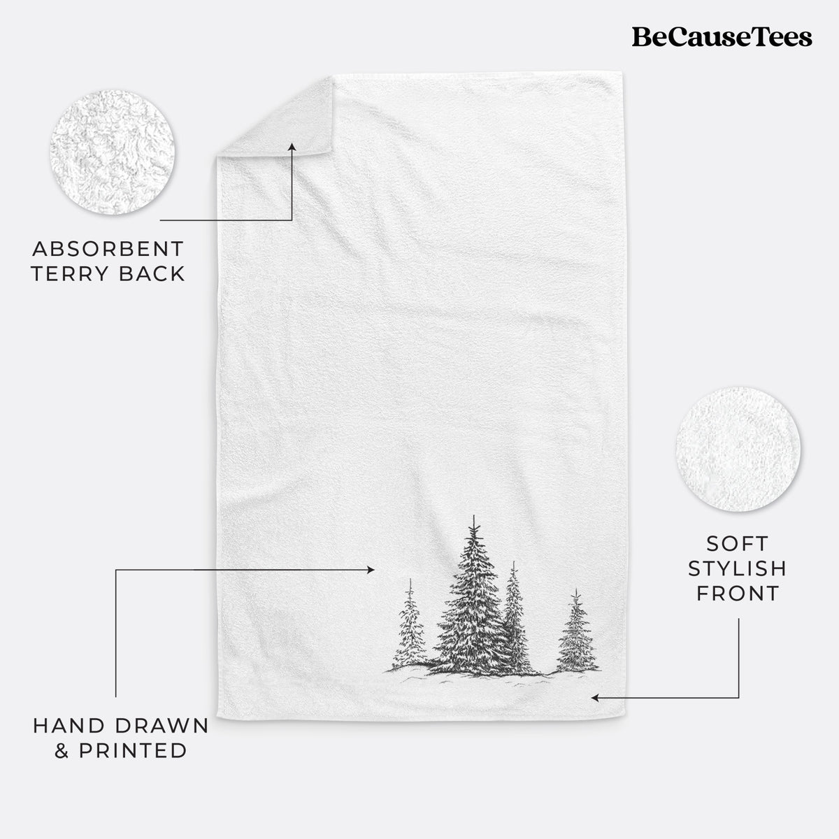 White hand towel printed with a black ink illustration of frost-covered evergreen trees.