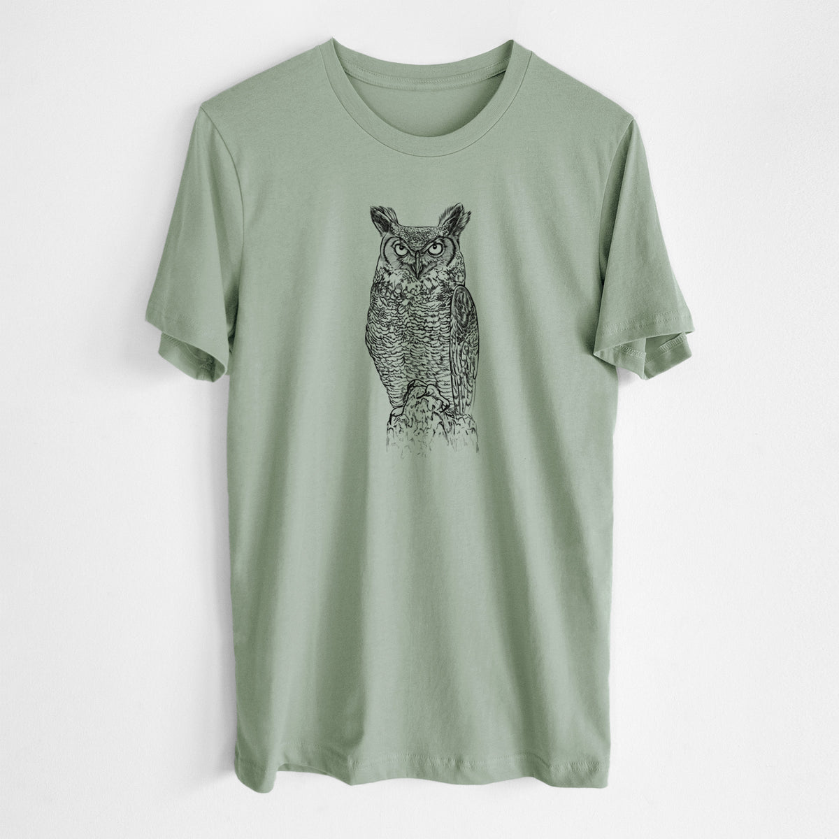 Sage green lightweight cotton t-shirt laid flat, printed with a detailed black ink illustration of a great horned owl standing upright with its ear tufts raised.