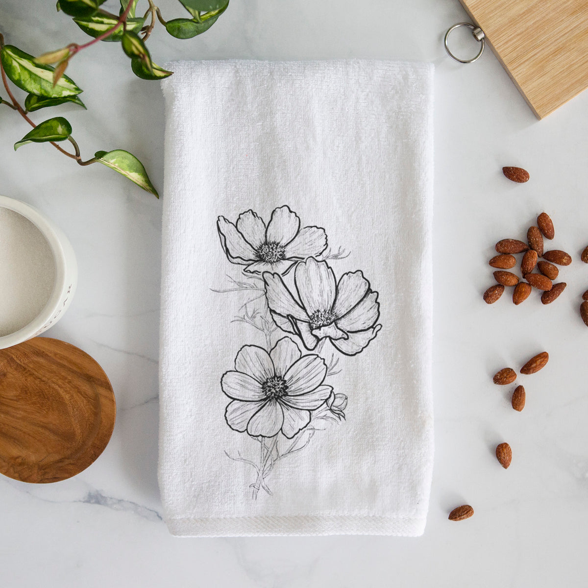 White hand towel printed with a black ink line drawing of garden cosmos flowers on stems.