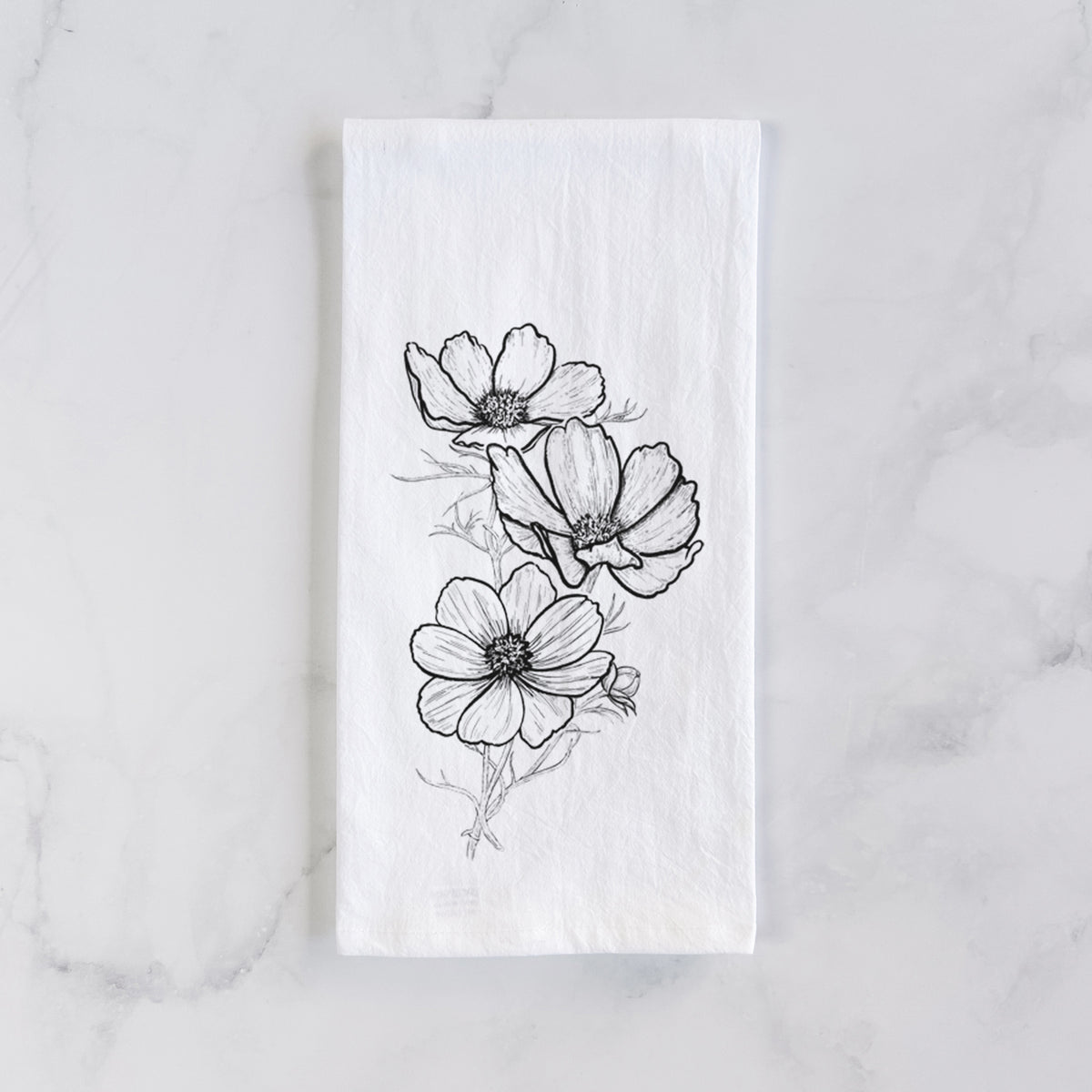 White cotton tea towel laid flat on marble, printed with a black ink line drawing of garden cosmos flowers on stems.