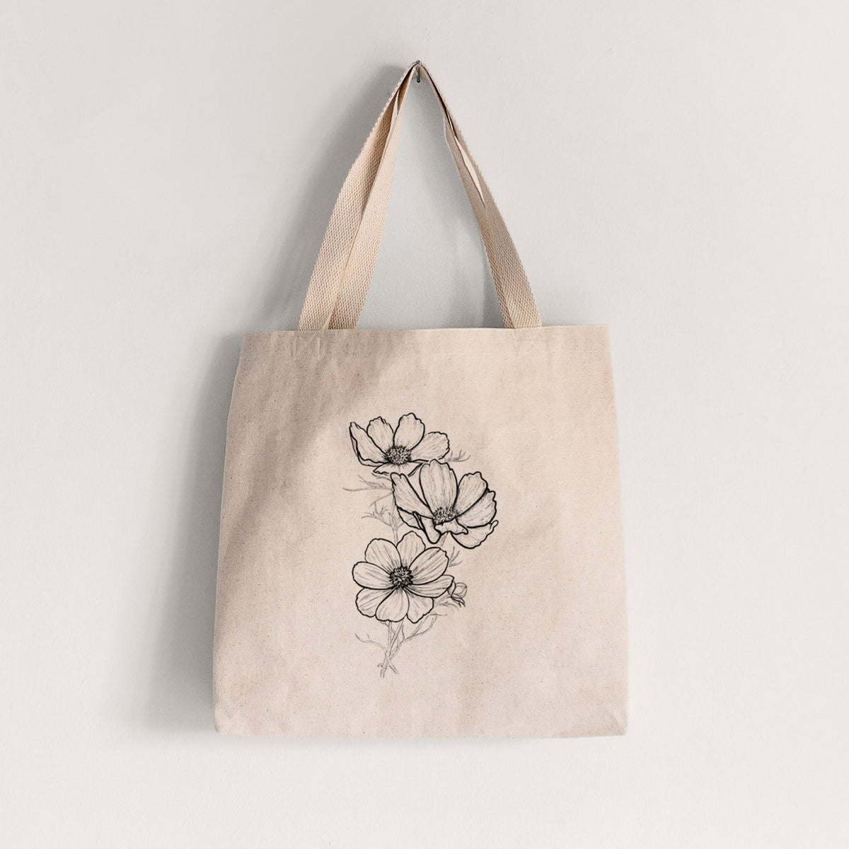Natural canvas tote bag printed with a black ink line drawing of garden cosmos flowers on stems.