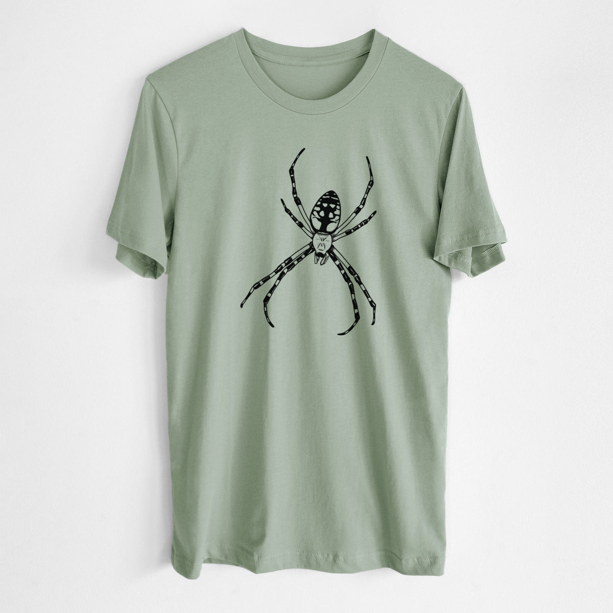 Sage green lightweight cotton t-shirt laid flat, printed with a detailed black ink illustration of a garden spider with long striped legs.