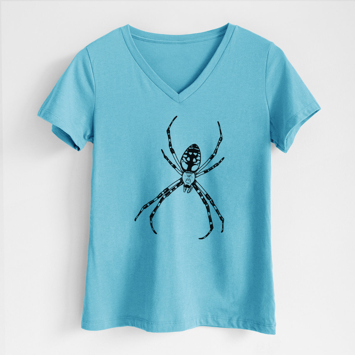 Turquoise women's relaxed fit cotton V-neck t-shirt laid flat, printed with a detailed black ink illustration of a garden spider with long striped legs.