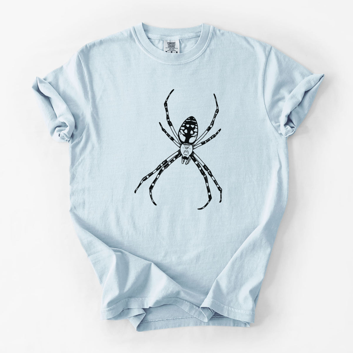 Chambray blue Comfort Colors t-shirt laid flat, printed with a detailed black ink illustration of a garden spider with long striped legs.