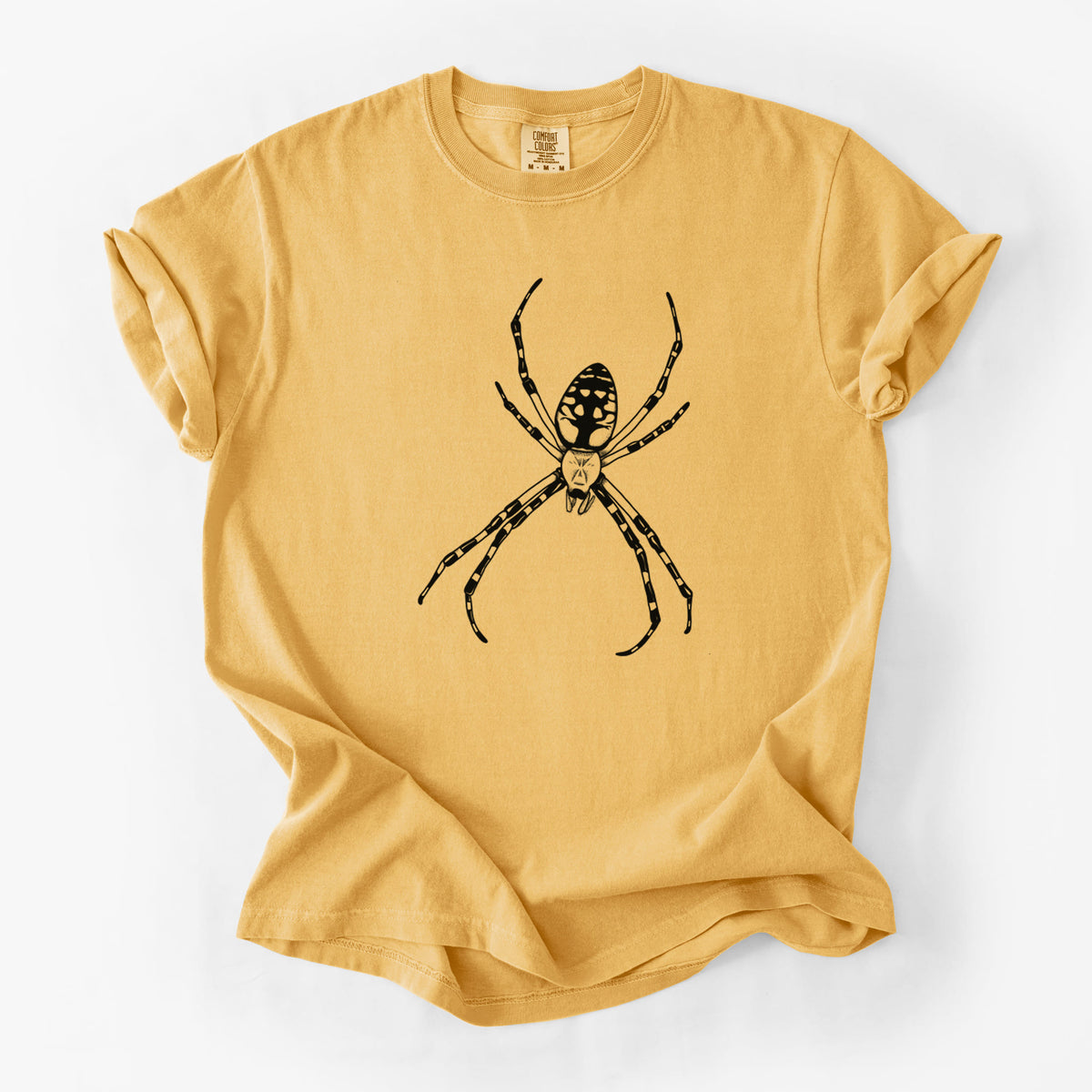 Golden wheat yellow Comfort Colors t-shirt laid flat, printed with a detailed black ink illustration of a garden spider with long striped legs.
