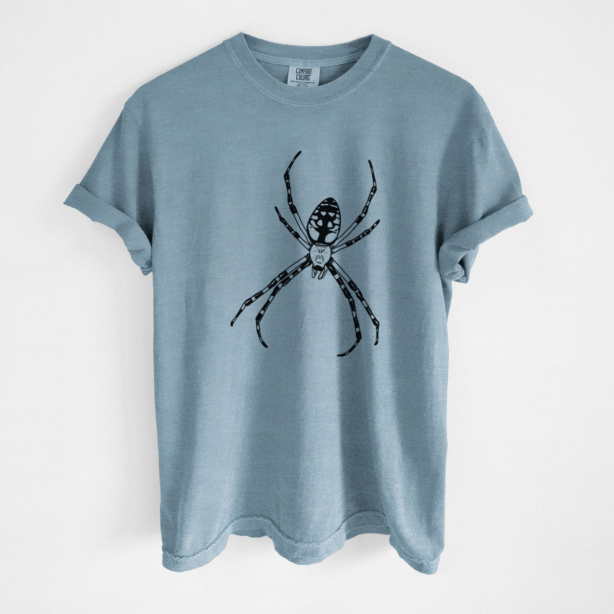 Steel blue Comfort Colors t-shirt laid flat, printed with a detailed black ink illustration of a garden spider with long striped legs.