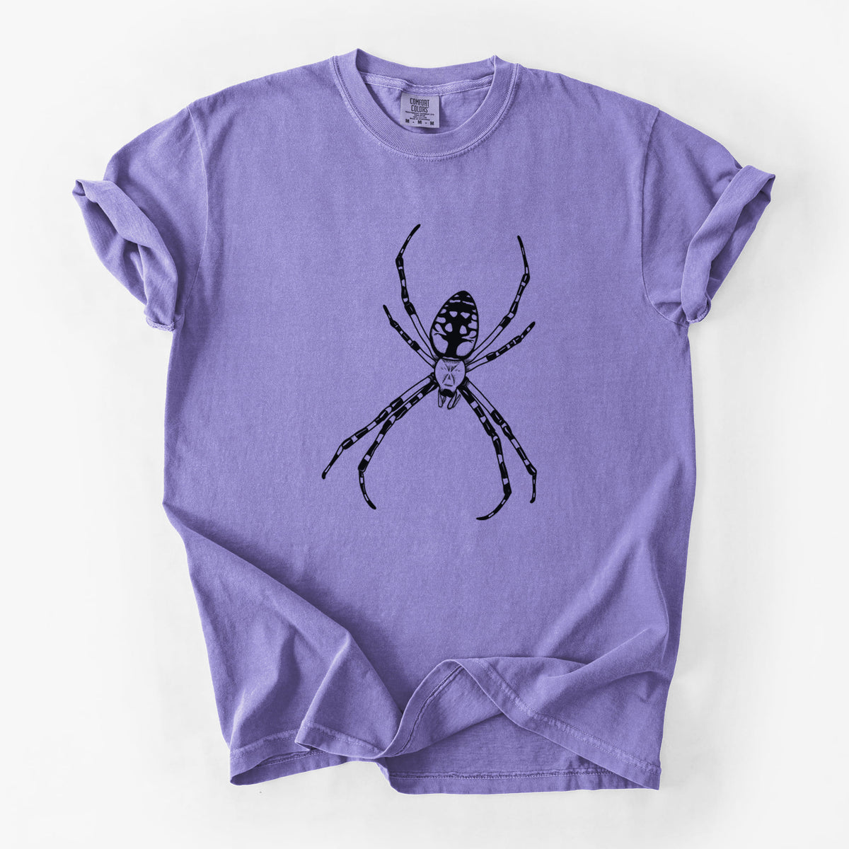 Violet purple Comfort Colors t-shirt laid flat, printed with a detailed black ink illustration of a garden spider with long striped legs.