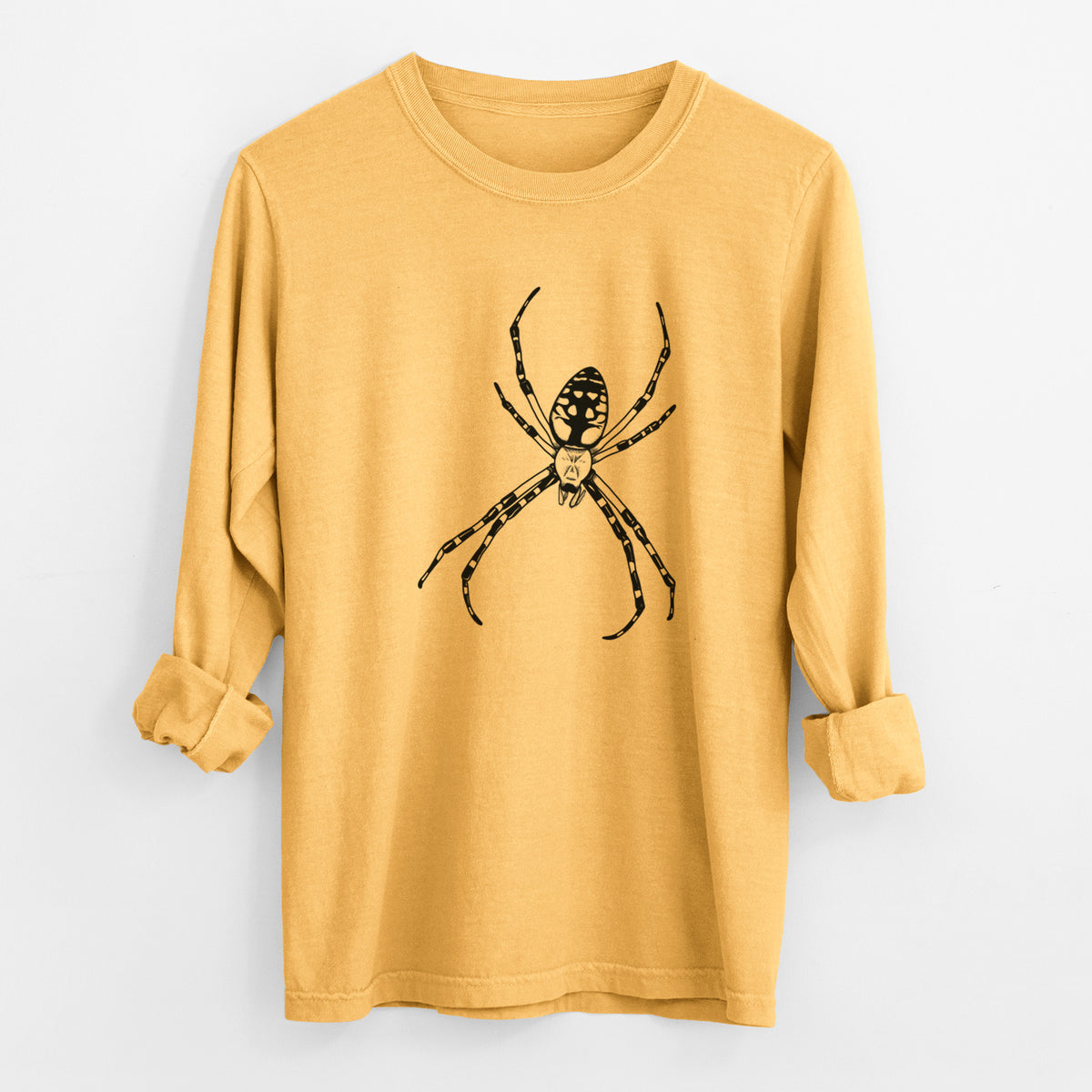 Golden wheat yellow Comfort Colors long sleeve shirt laid flat with the cuffs rolled, printed with a detailed black ink illustration of a garden spider with long striped legs.
