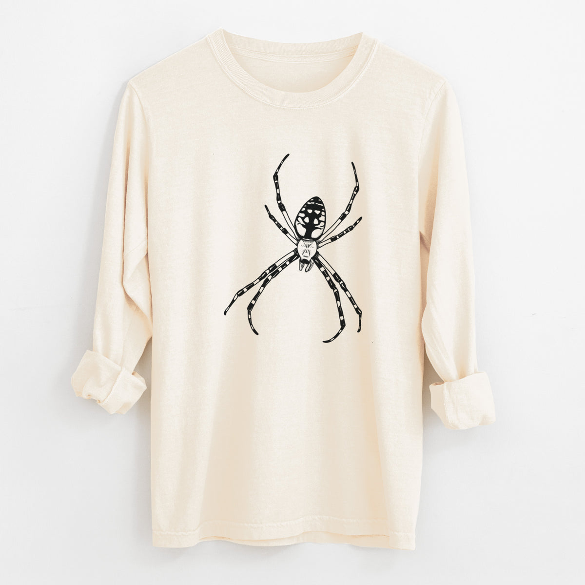 Ivory Comfort Colors long sleeve shirt laid flat with the cuffs rolled, printed with a detailed black ink illustration of a garden spider with long striped legs.