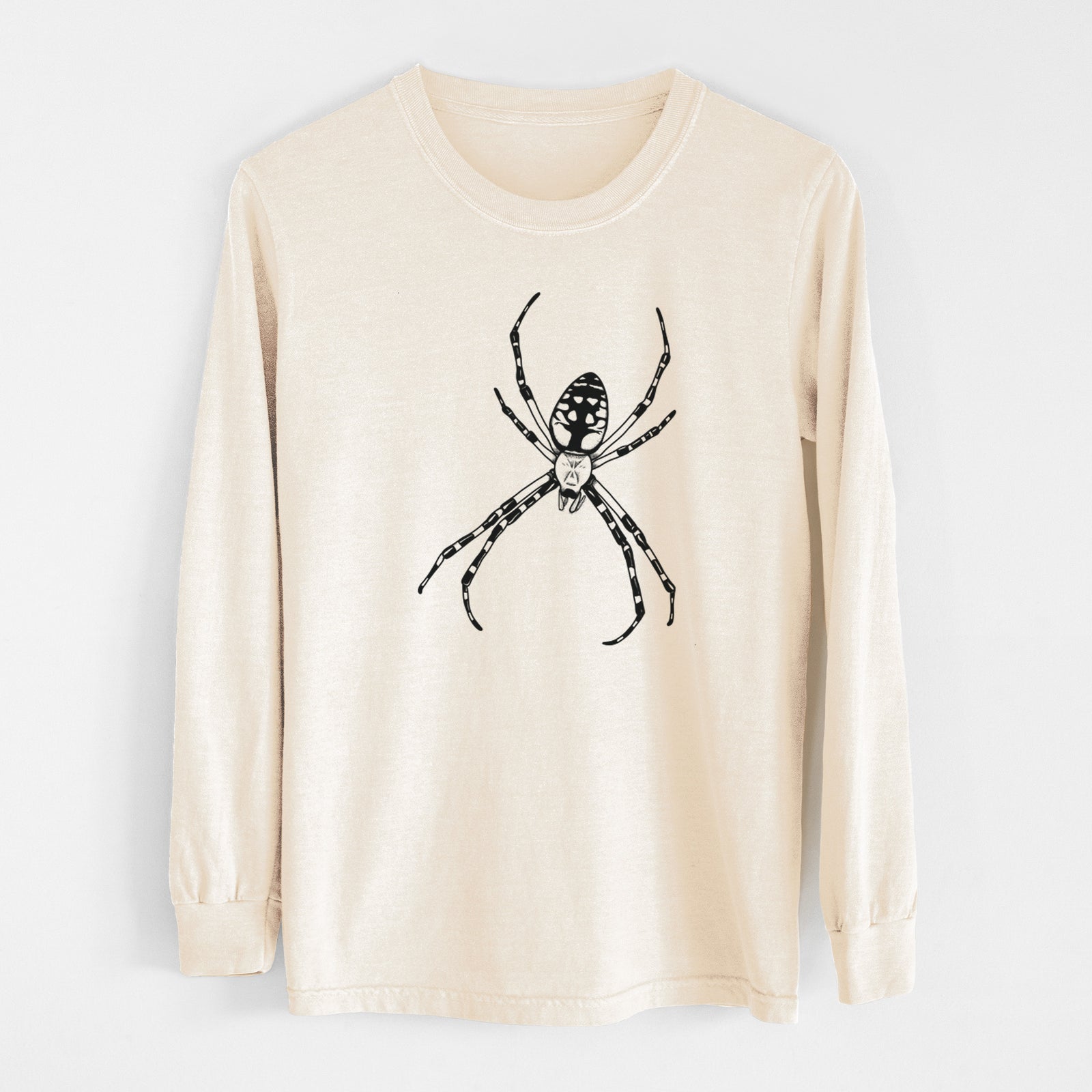 Ivory Comfort Colors long sleeve shirt laid flat, printed with a detailed black ink illustration of a garden spider with long striped legs.