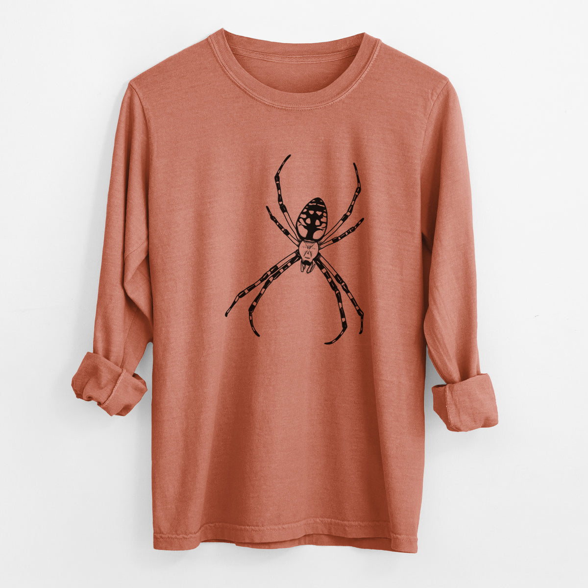 Yam burnt orange Comfort Colors long sleeve shirt laid flat with the cuffs rolled, printed with a detailed black ink illustration of a garden spider with long striped legs.