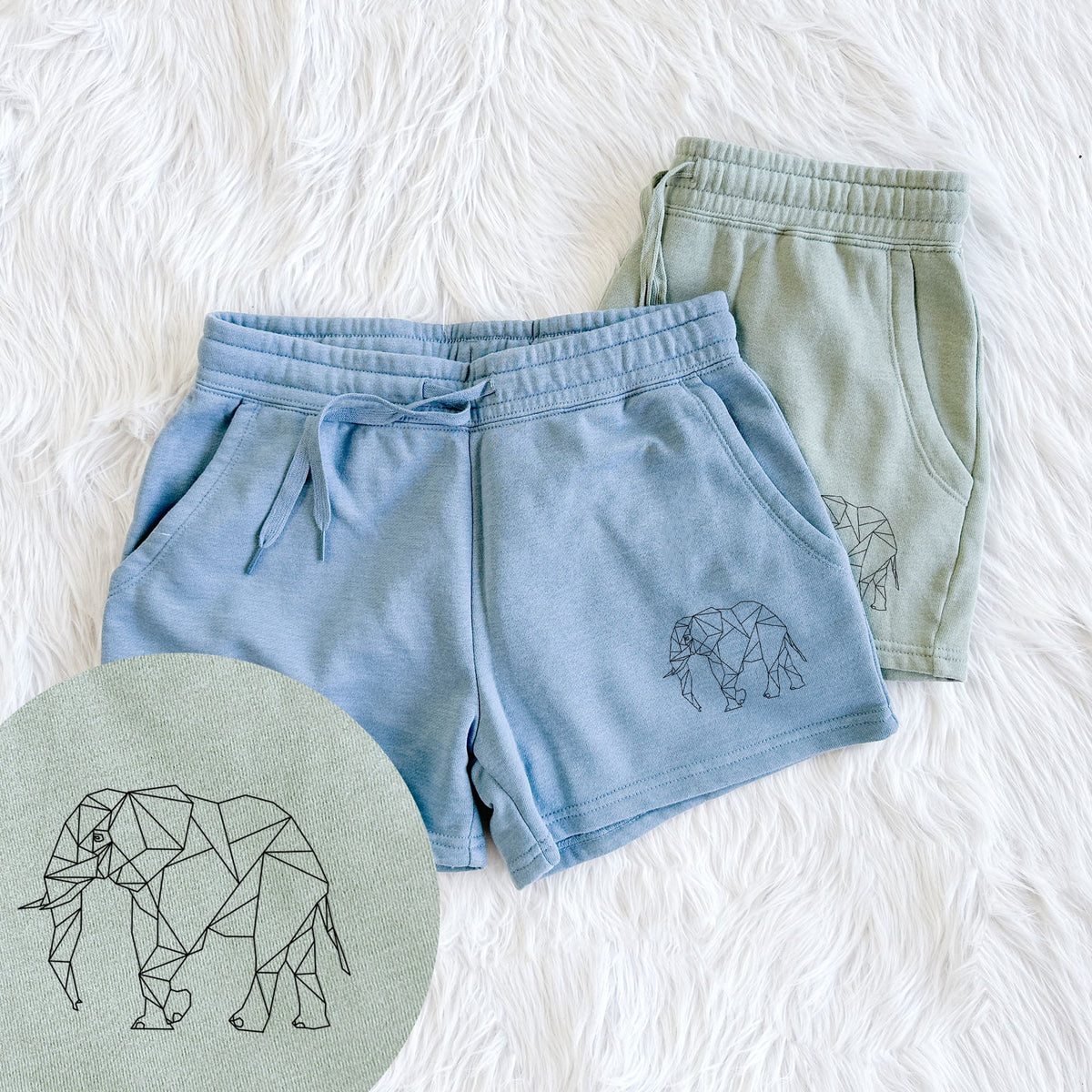 Two pairs of Cali Wave shorts in different colors printed with a black geometric line art elephant, with a close-up of the print.