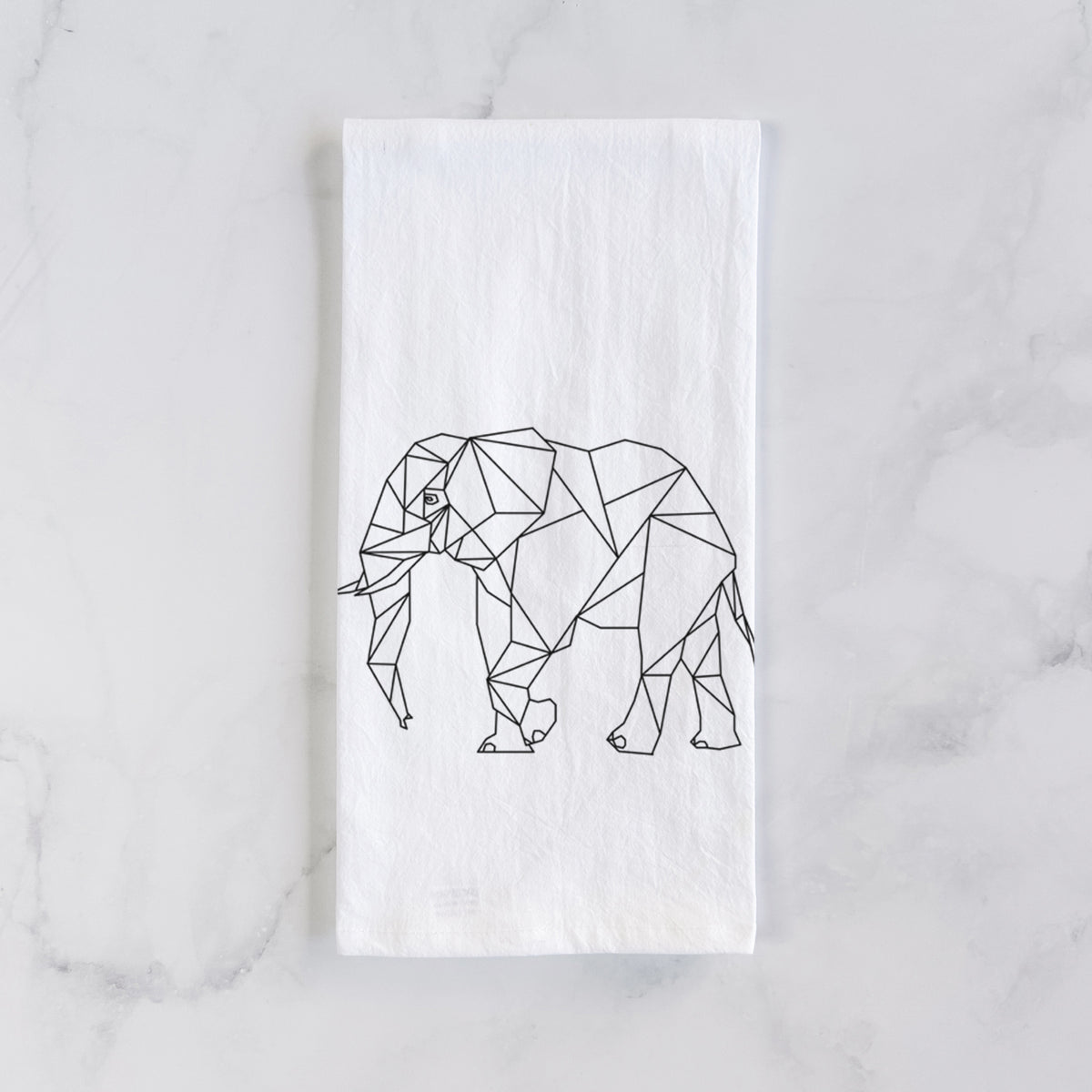 White cotton tea towel laid flat on marble, printed with a black geometric line art elephant.