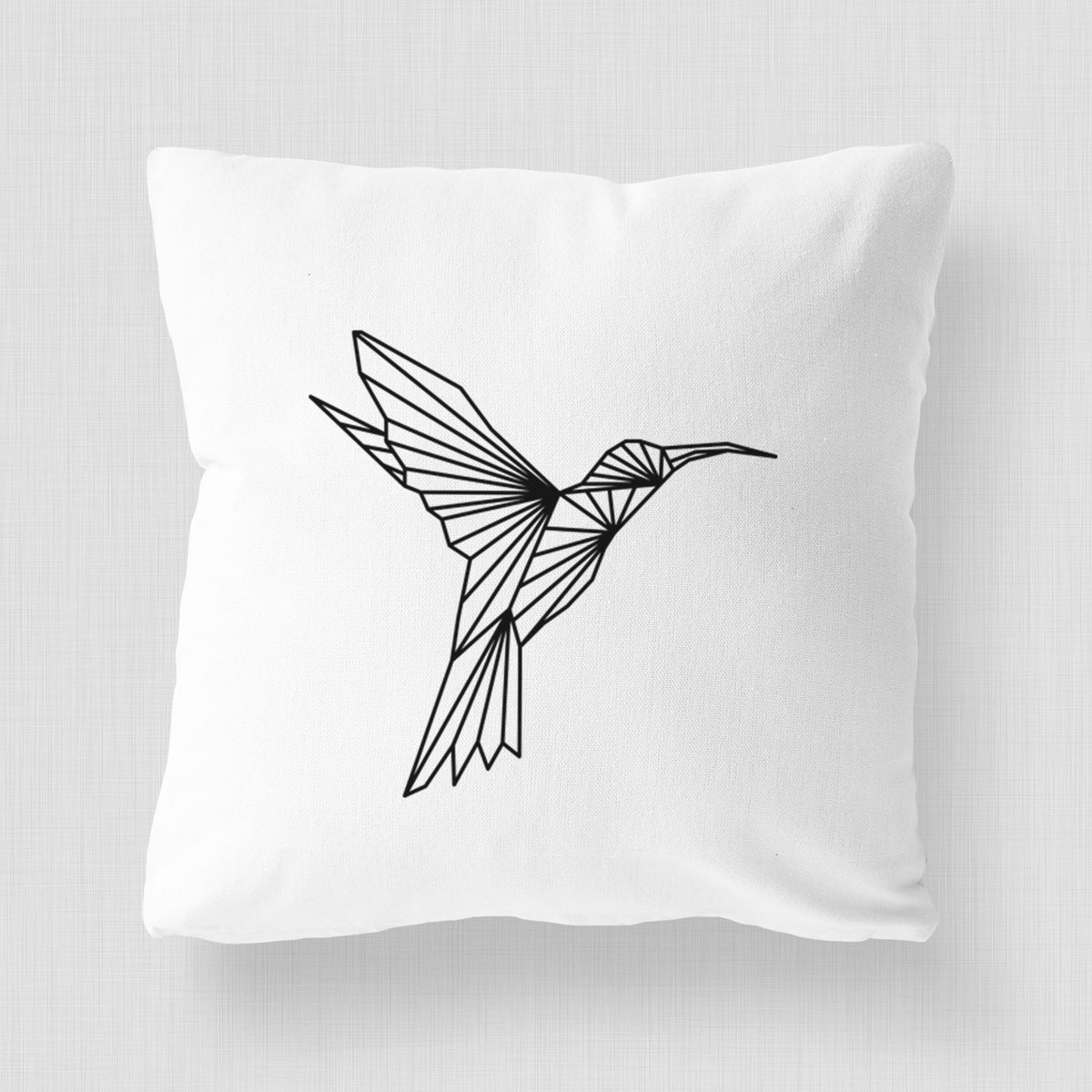 White pillow cover printed with a black geometric line art hummingbird in flight.