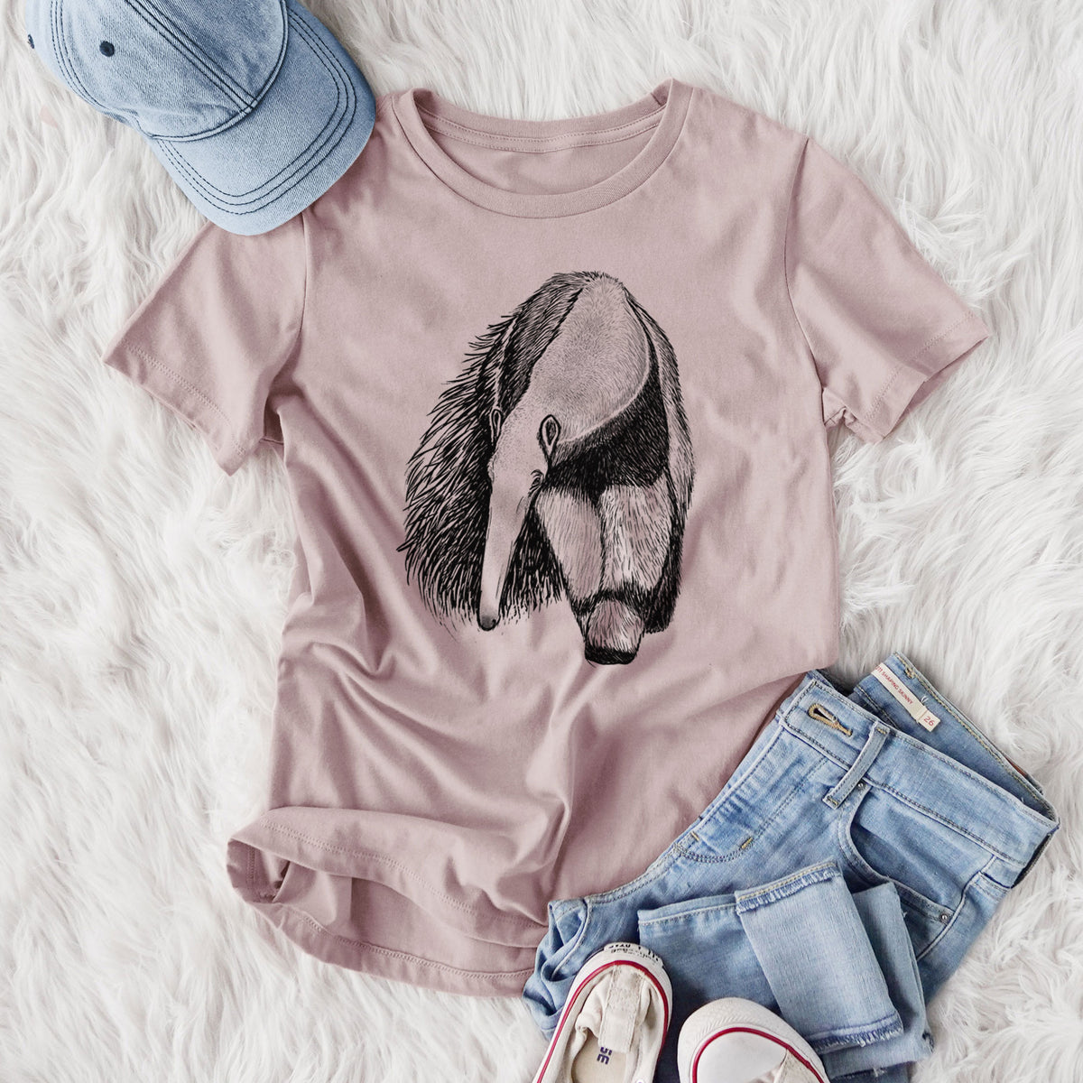 Women's relaxed fit cotton t-shirt printed with a detailed black ink illustration of a giant anteater with its long snout and bushy tail, styled flat on a white faux fur rug with jeans.