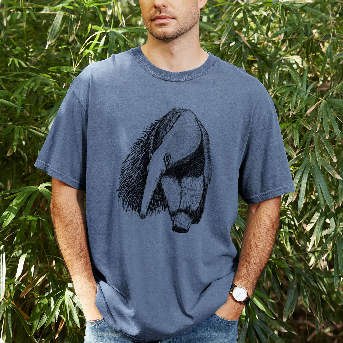 Man wearing a Comfort Colors t-shirt printed with a detailed black ink illustration of a giant anteater with its long snout and bushy tail, outdoors.