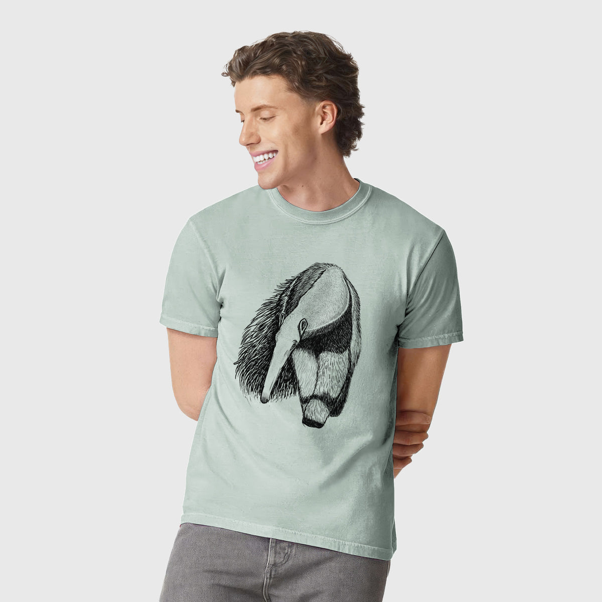 Man wearing a Comfort Colors t-shirt printed with a detailed black ink illustration of a giant anteater with its long snout and bushy tail.