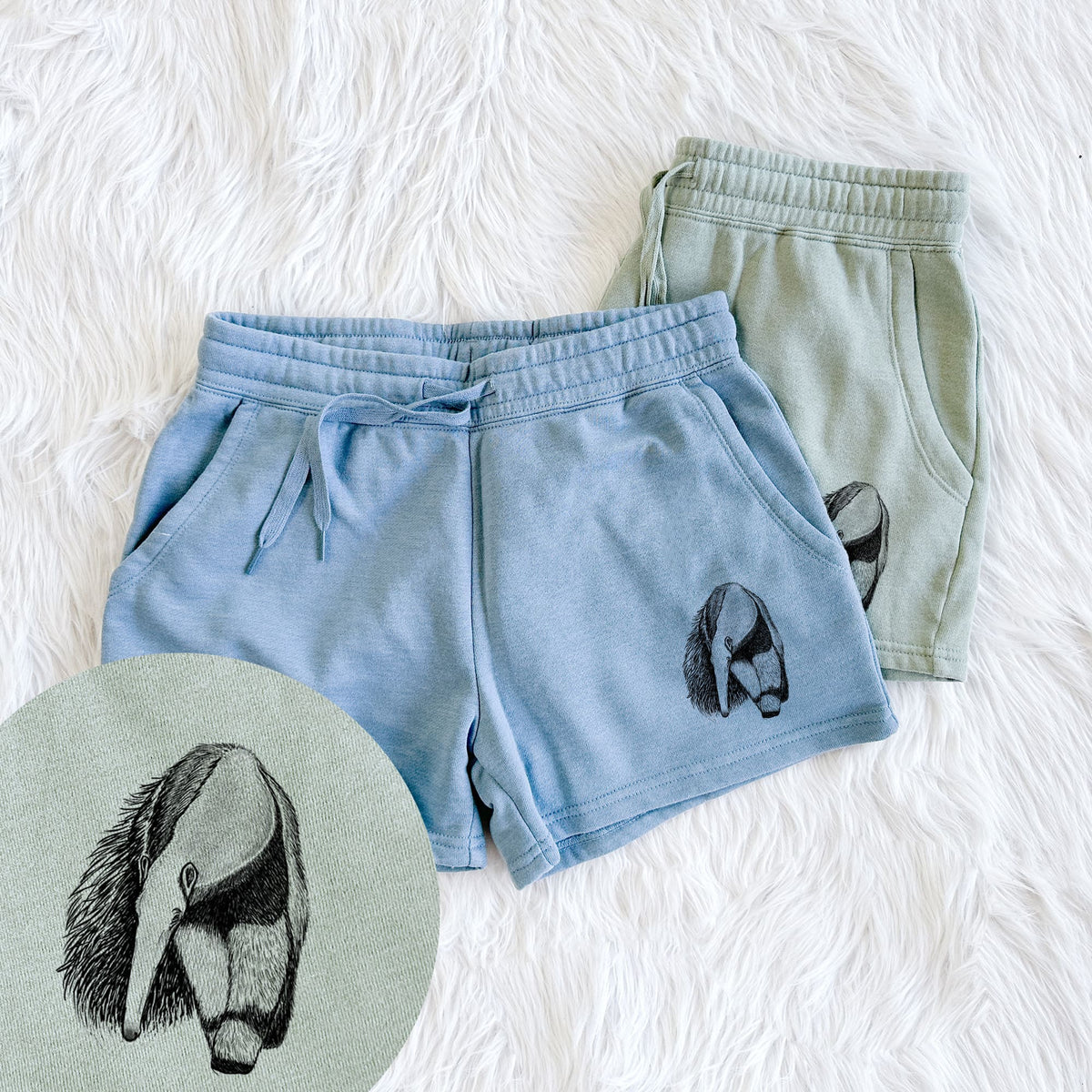 Two pairs of Cali Wave shorts in different colors printed with a detailed black ink illustration of a giant anteater with its long snout and bushy tail, with a close-up of the print.
