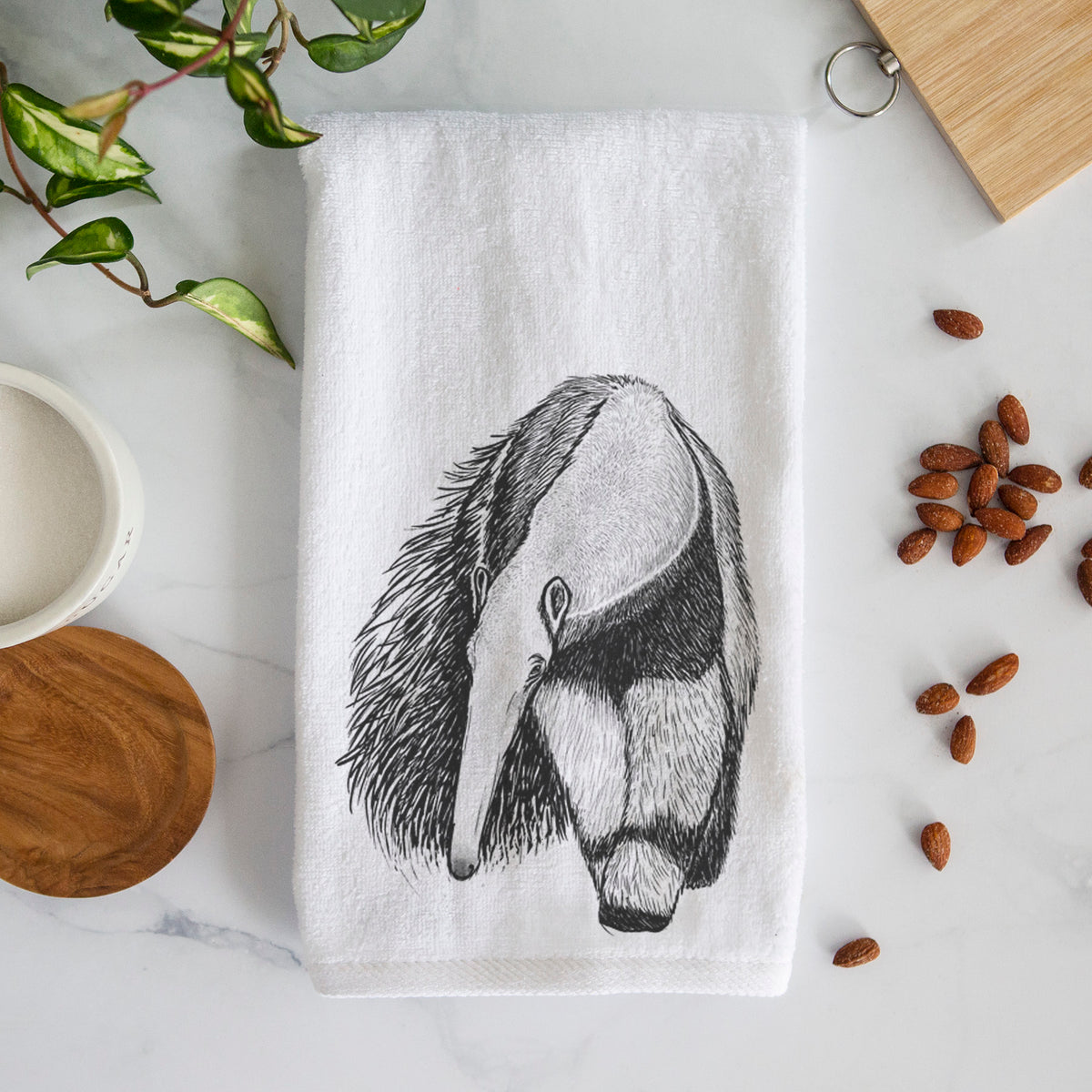 White hand towel printed with a detailed black ink illustration of a giant anteater with its long snout and bushy tail.