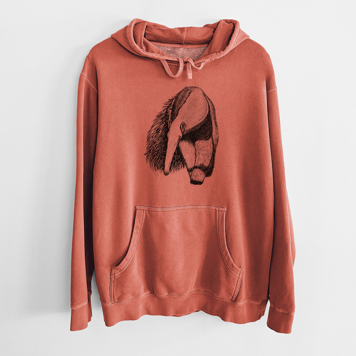 Amber orange pigment dyed hoodie laid flat, printed with a detailed black ink illustration of a giant anteater with its long snout and bushy tail.