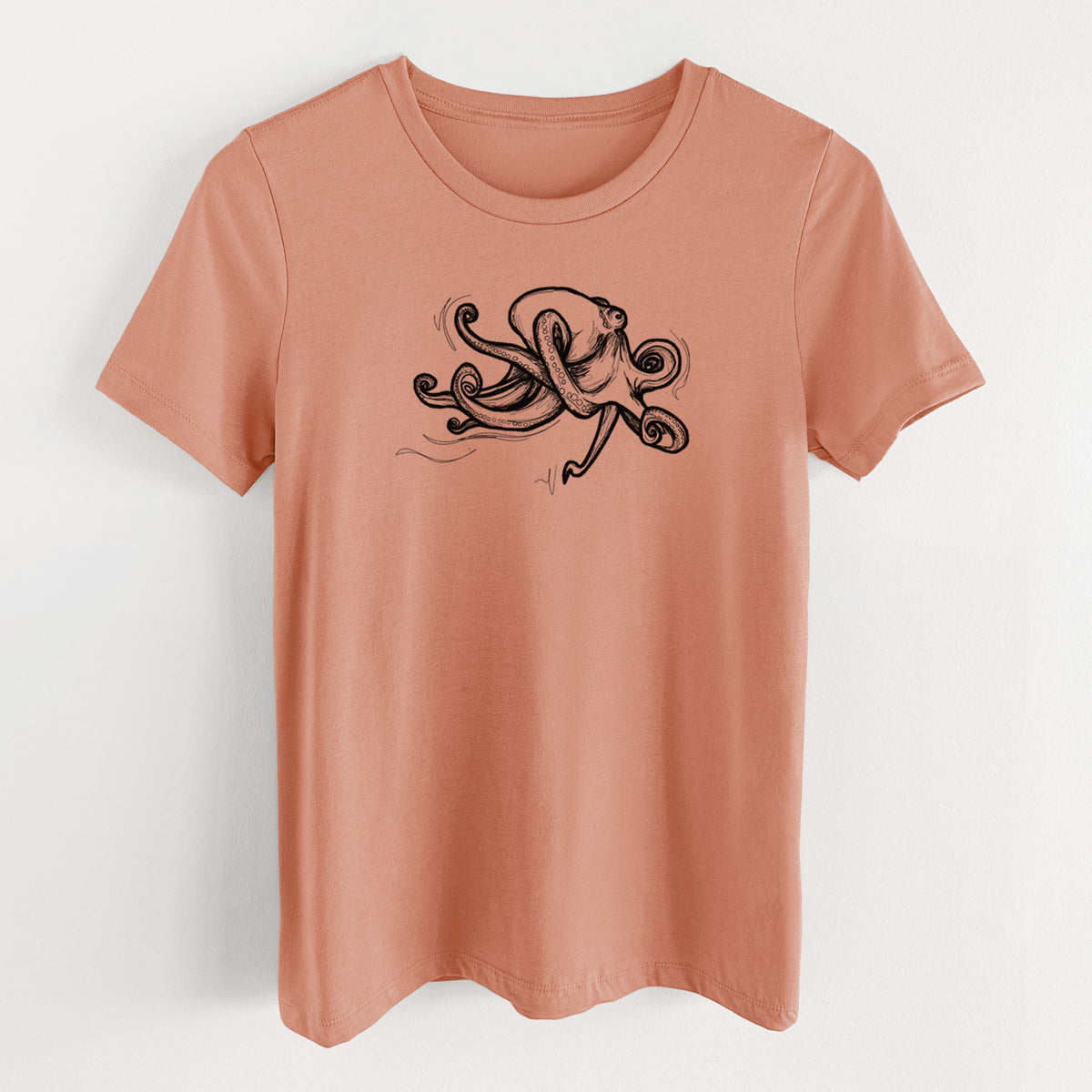 Terracotta orange women's relaxed fit cotton t-shirt laid flat, printed with a black ink illustration of a giant Pacific octopus with curling tentacles.