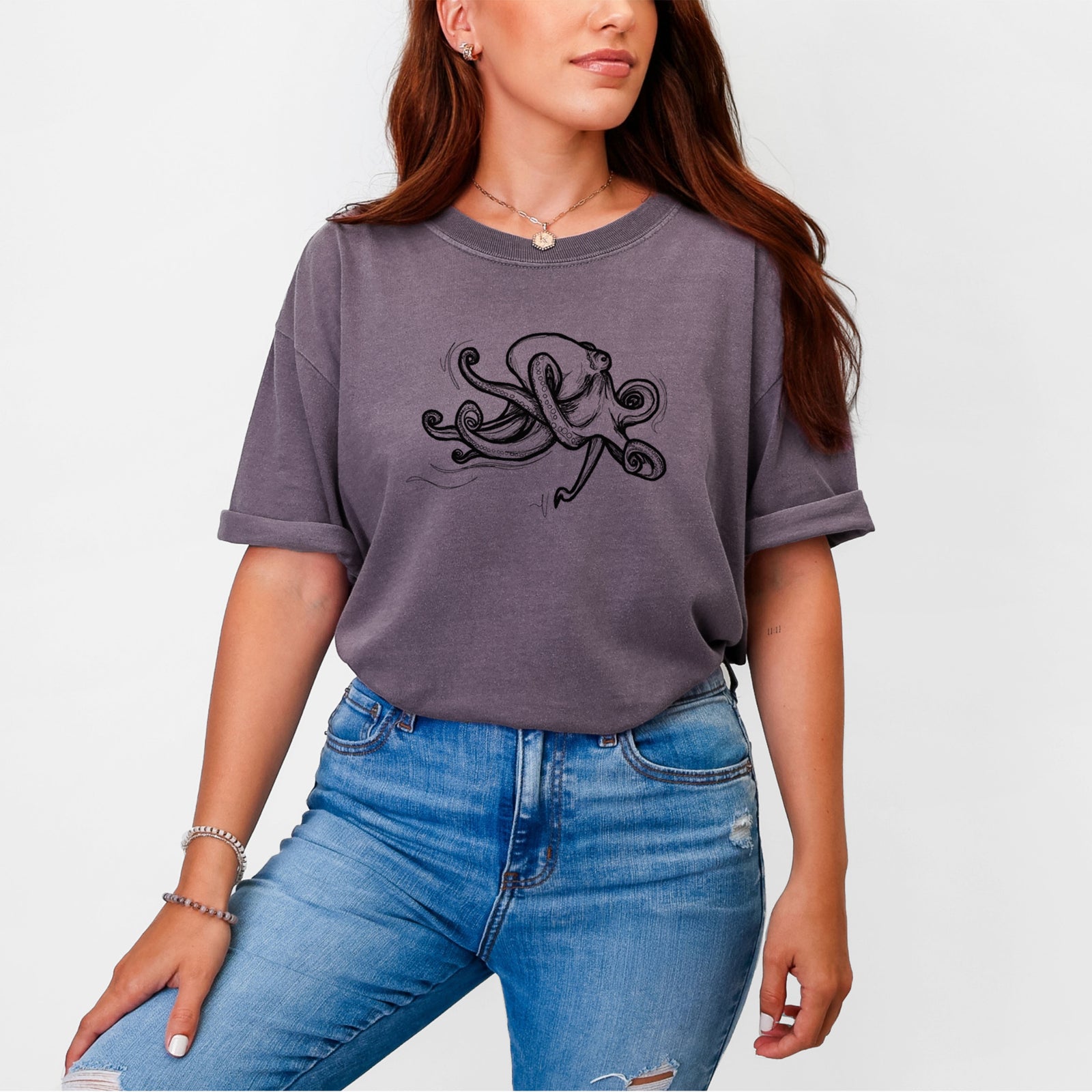 Blue jean Comfort Colors t-shirt laid flat, printed with a black ink illustration of a giant Pacific octopus with curling tentacles.